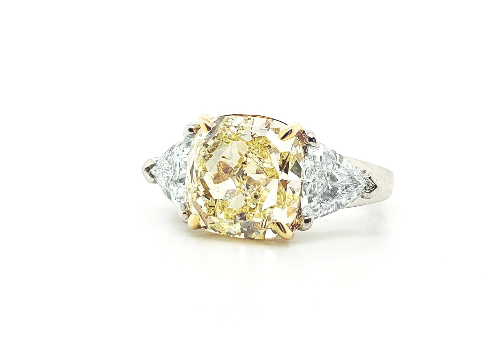From SCARSELLI, this gorgeously cut 5.00 Fancy Yellow Cushion diamond ring is set with a pair of white side trilliant diamonds.  (2 = 1.55 carats) H color VS clarity.  This ring may be sized or the center diamond re-designed with Scarselli to suit