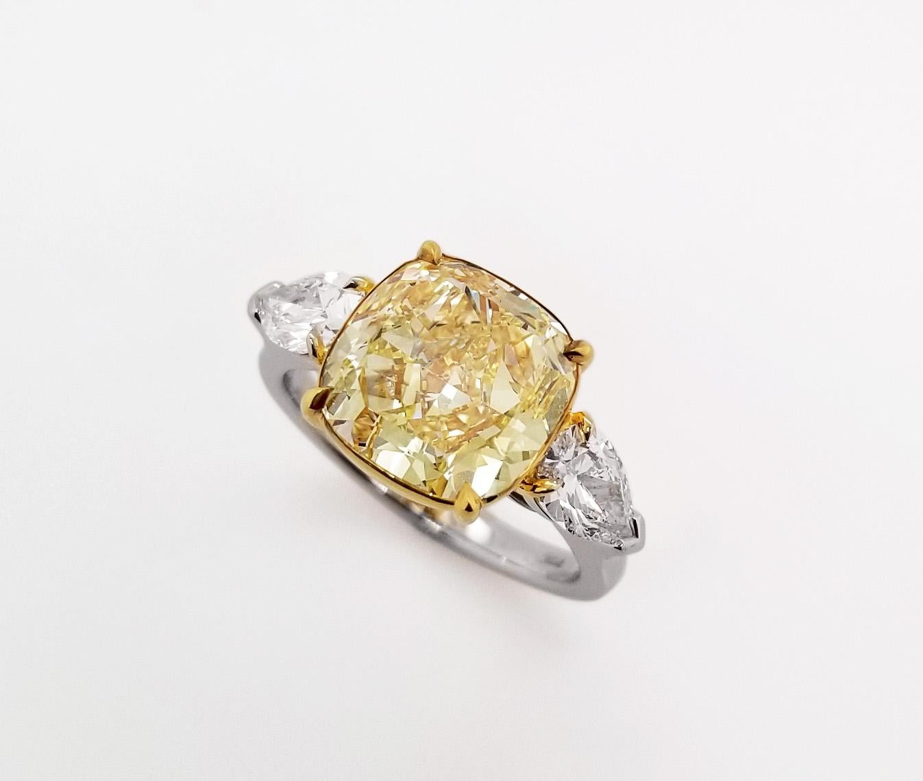 From SCARSELLI, this 5-carat Fancy Yellow Diamond GIA certified (see certificate picture for detailed stone information). The diamond is flanked by a pair of pear shape  1.01 carats together VS clarity. This ring may be sized with Scarselli to