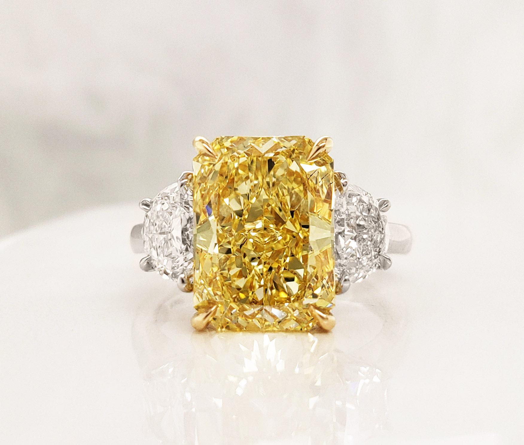 From SCARSELLI, this astonishing statement ring features a 5.01 carats Fancy Intense Yellow radiant cut diamond of VS2 clarity flanked with half-moon cut white diamonds 1.10 carats (0.55 each). Platinum and 18k yellow gold ring perfect for any