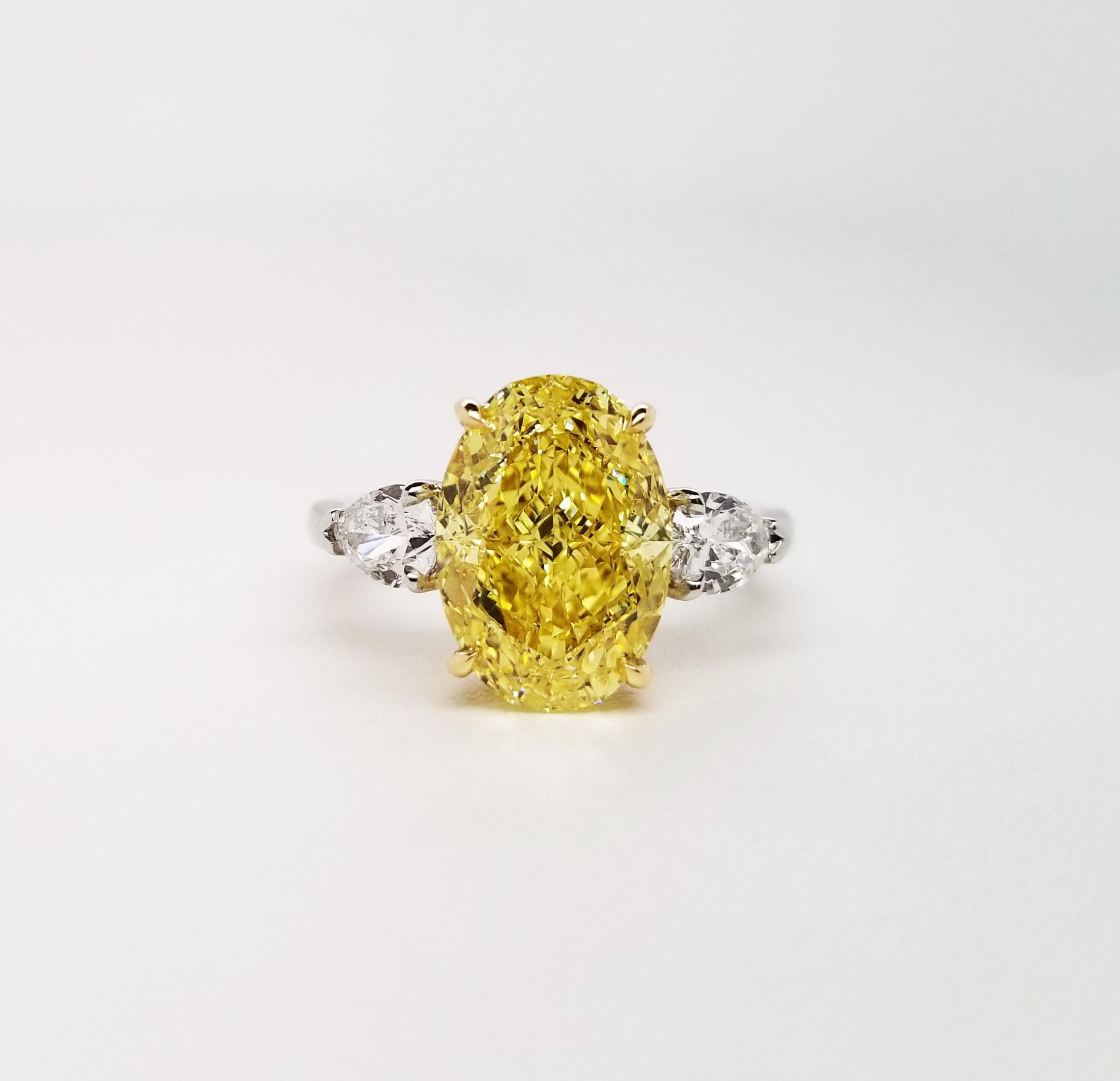 This Beautiful Classic engagement ring from Scarselli features an over 5 carat fancy vivid yellow oval cut diamond GIA certified (see certificate picture for more detailed stone's information) flanked by a couple of GIA certified pear-shaped E