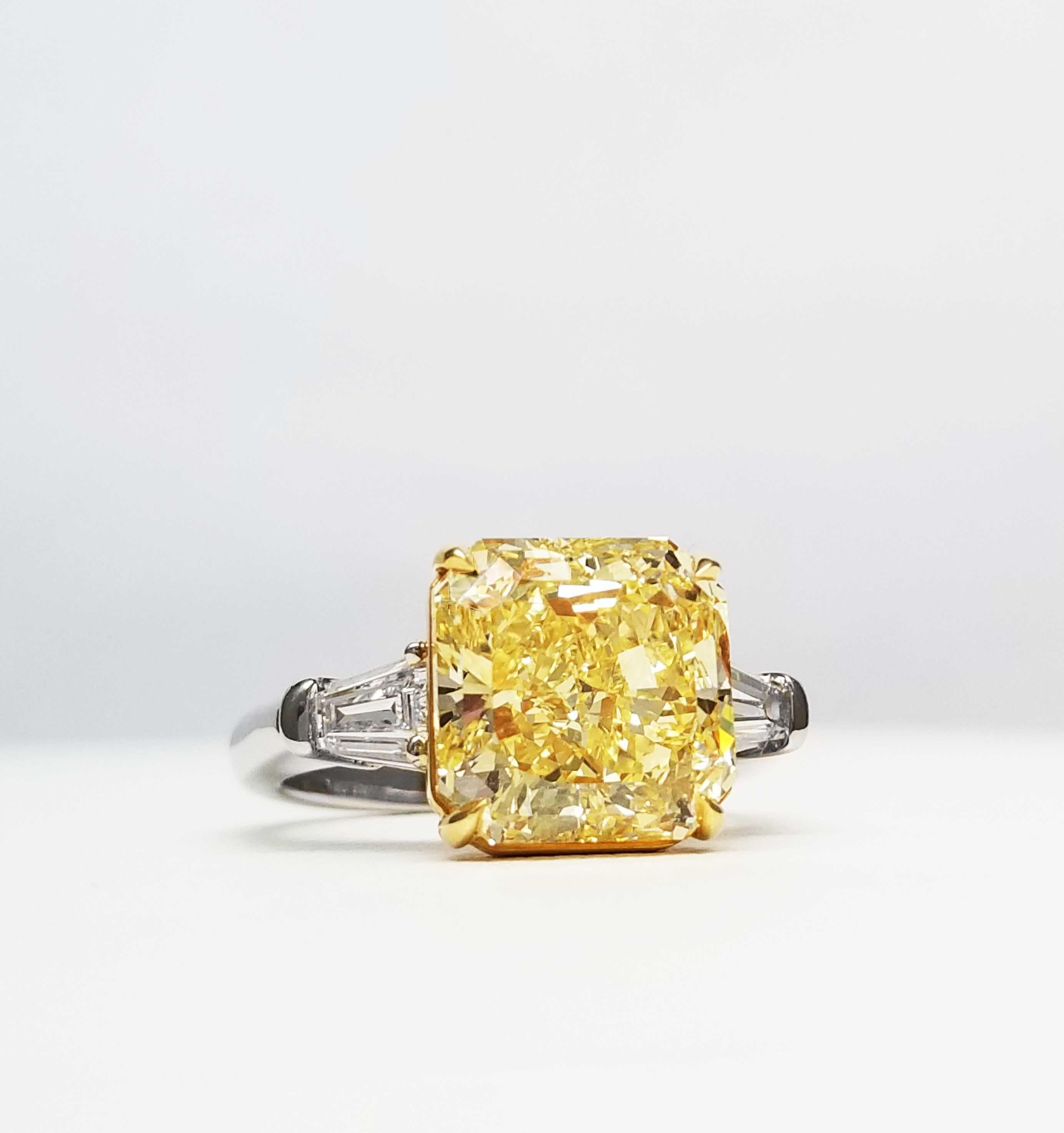 From SCARSELLI, this vibrant and spectacular 6.04-carat Fancy Intense Yellow Diamond (VS1 clarity) is flanked by a 0.40 carats total pair of white tapered baguette diamonds for classic appeal.  The mounting is hand made with yellow gold seat and