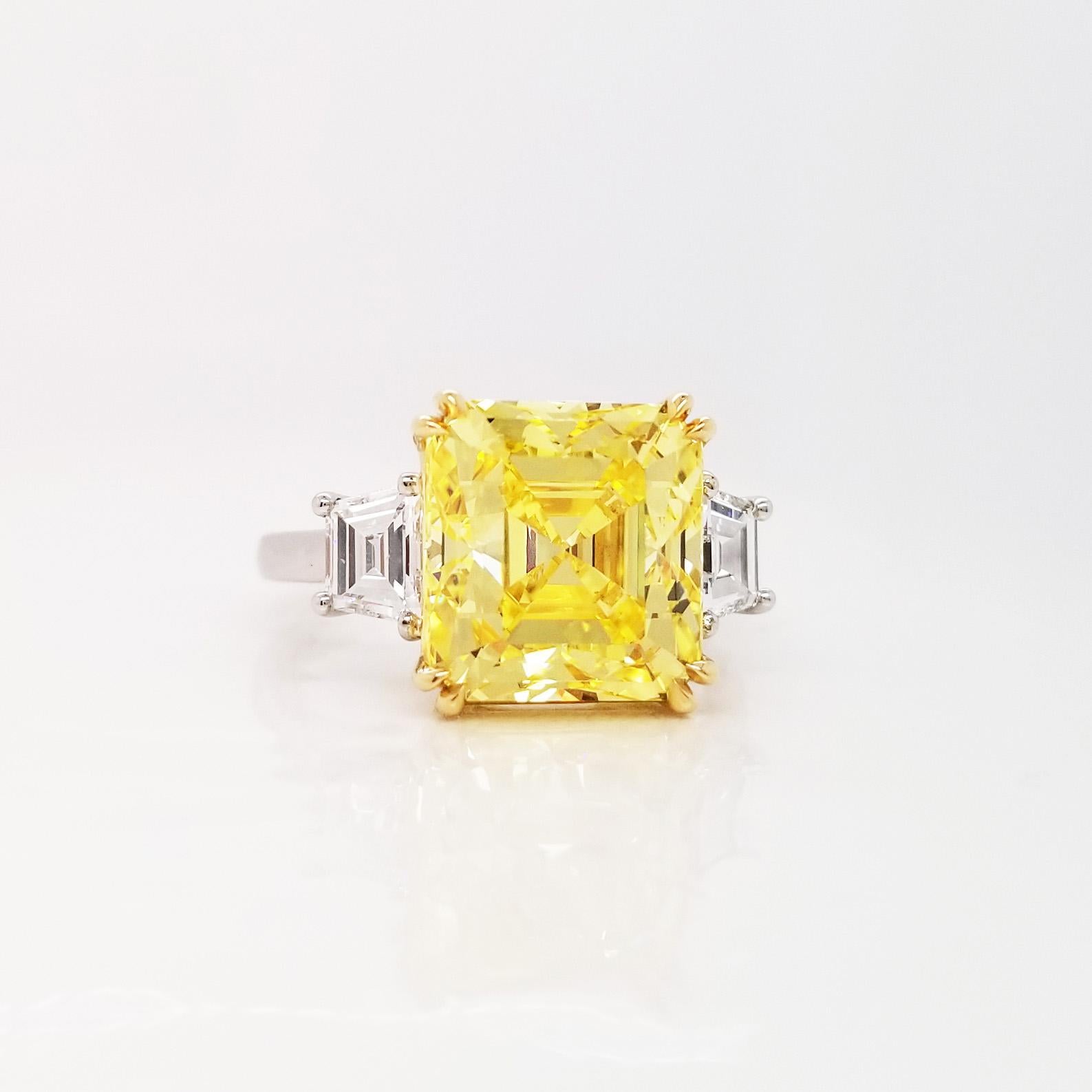 From SCARSELLI, this beautiful statement ring features a 6-carat Fancy Vivid Yellow Radiant Cut Diamond of VS2 clarity flanked by a couple of E color VS clarity trapezoid cut white diamonds totaling 0.76 carats (see GIA certificate picture for more