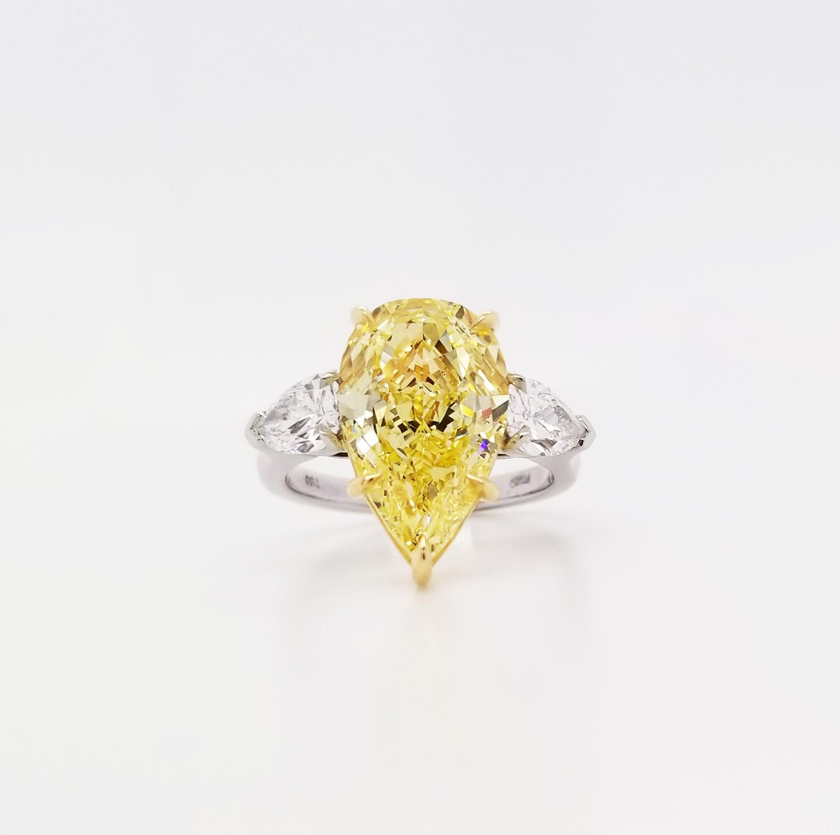From SCARSELLI, this 5-carat Fancy Yellow Pear shape Cut Diamond is GIA certified (see certificate picture for detailed stone information). The diamond is flanked by a pair of pear shape  1.01 carats together VS clarity. This ring may be sized with