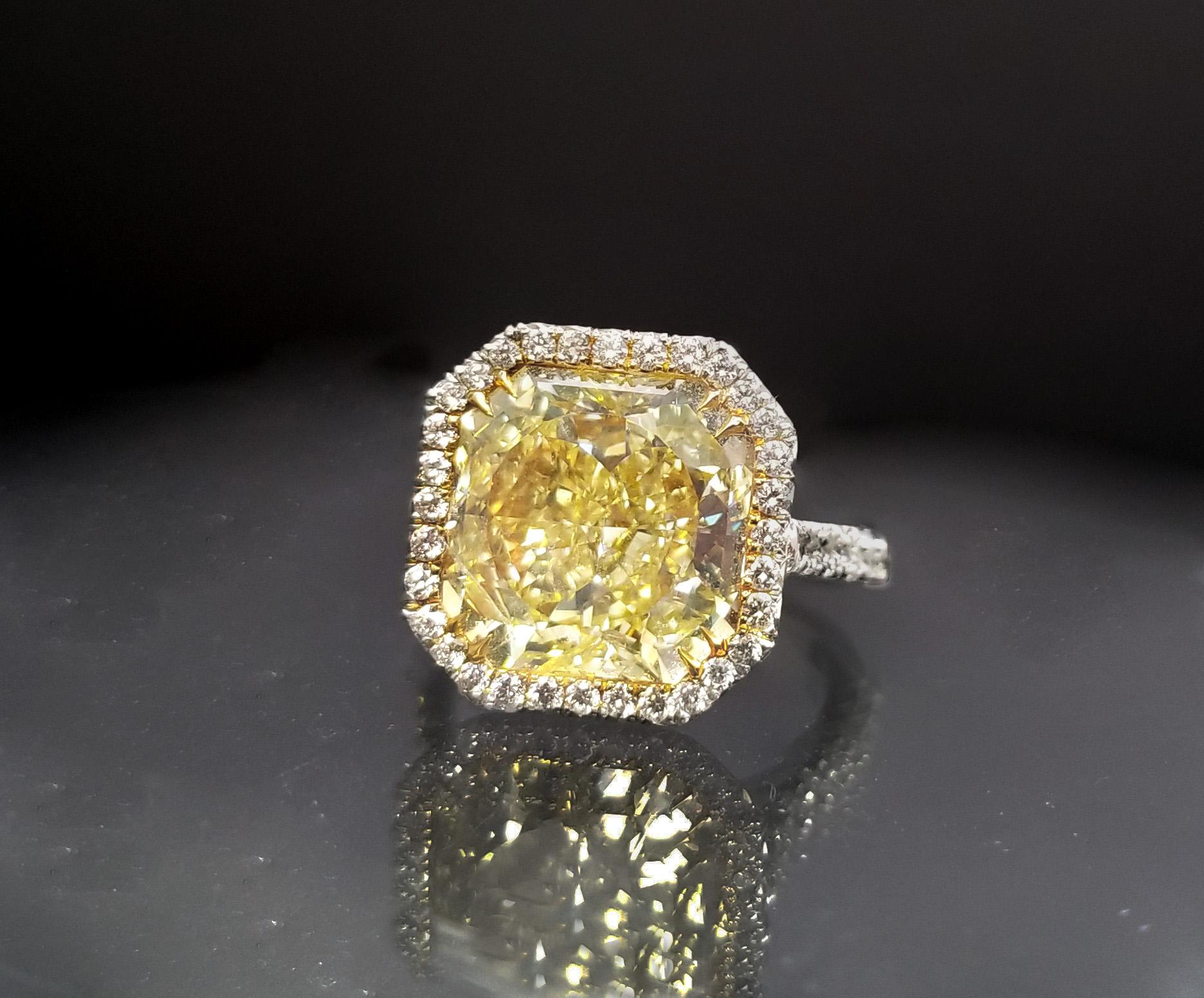 From SCARSELLI, this spectacular 7 carat Fancy Intense Yellow Diamond, with a halo of round white diamonds that spread down on the shank's sides (see certificate pictures for detailed stone information) The mounting is handmade in platinum and 18k