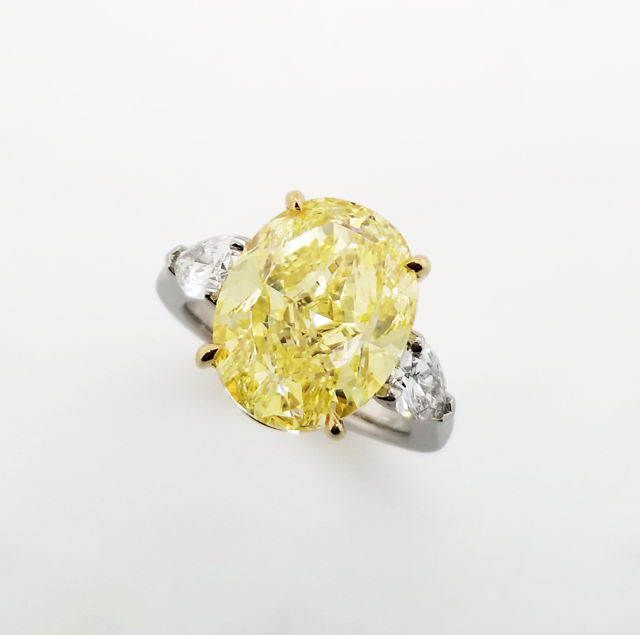 SCARSELLI is featuring an 8 + carat Fancy Intense Yellow Oval Cut Diamond VS1 clarity, certified by GIA ( see certificate picture for detailed stone information ) flanked by a pair of pear shaped natural F diamonds VVS/VS clarity 0.40ct each GIA