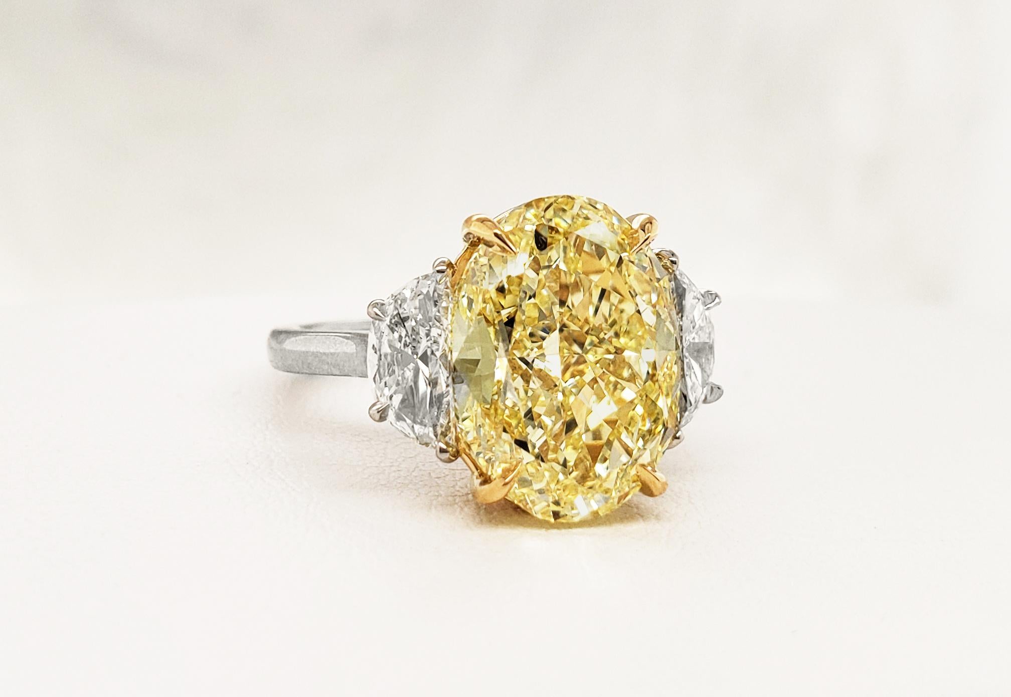 Scarselli's Classic Ring features an 6.70 carat Fancy Yellow Oval Diamond with GIA certificate 6177522925 (see picture for details of the stone) . The center diamond is accompanied by two white half-moon cut diamonds, VS1 clarity 1.00 total carat
