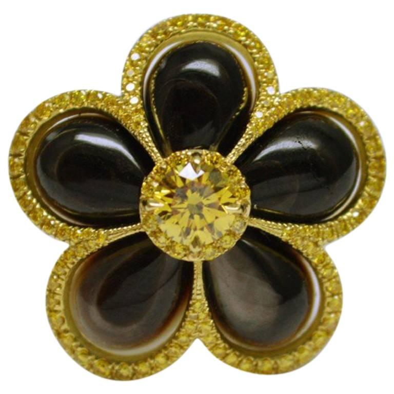 GIA-Certified 0.46-carat Natural Fancy Vivid Yellow Round Brilliant diamond mounted in in 18 karat yellow gold and black mother of pearl ring with rich natural yellow diamond accents. Flower ring featuring GIA-Certified fancy vivid yellow round