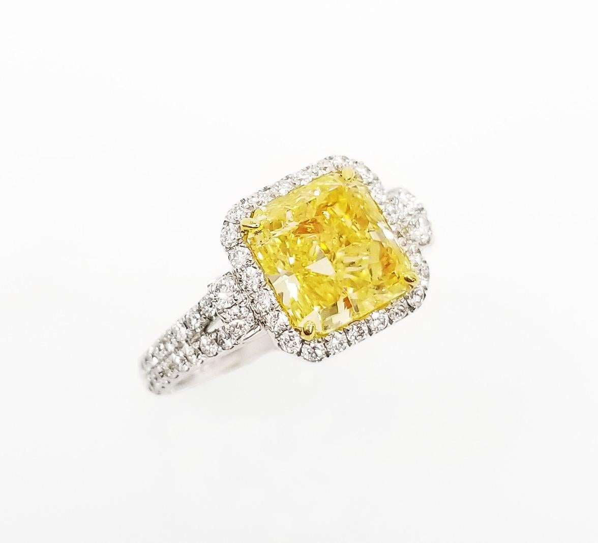 From the Collection of Scarselli, this gorgeous 2.46 carat Natural Fancy Intense Yellow Radiant cut Diamond set in an 18 karat white gold ring with 0.56 total carats of additional  round brilliant diamonds for a clean and sophisticated look. This