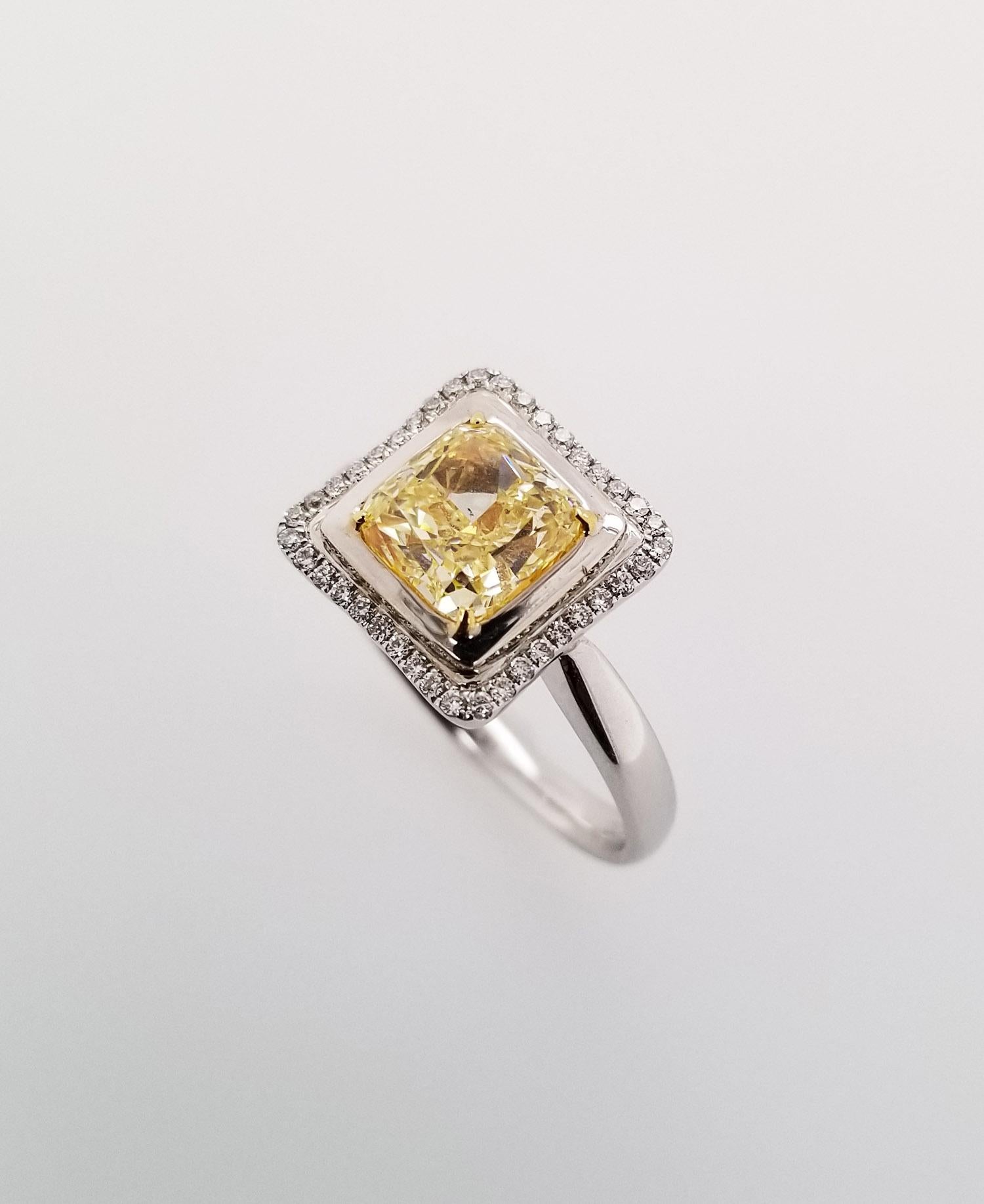 2.02 Carat Fancy Yellow GIA-Certified Radiant Cut SI1 Diamond Engagement Ring with 18 Karat White Gold. Features a halo-setting with a row of white round cut diamonds, TCW 0.13. Resizable upon request.

This remarkable engagement ring highlights an