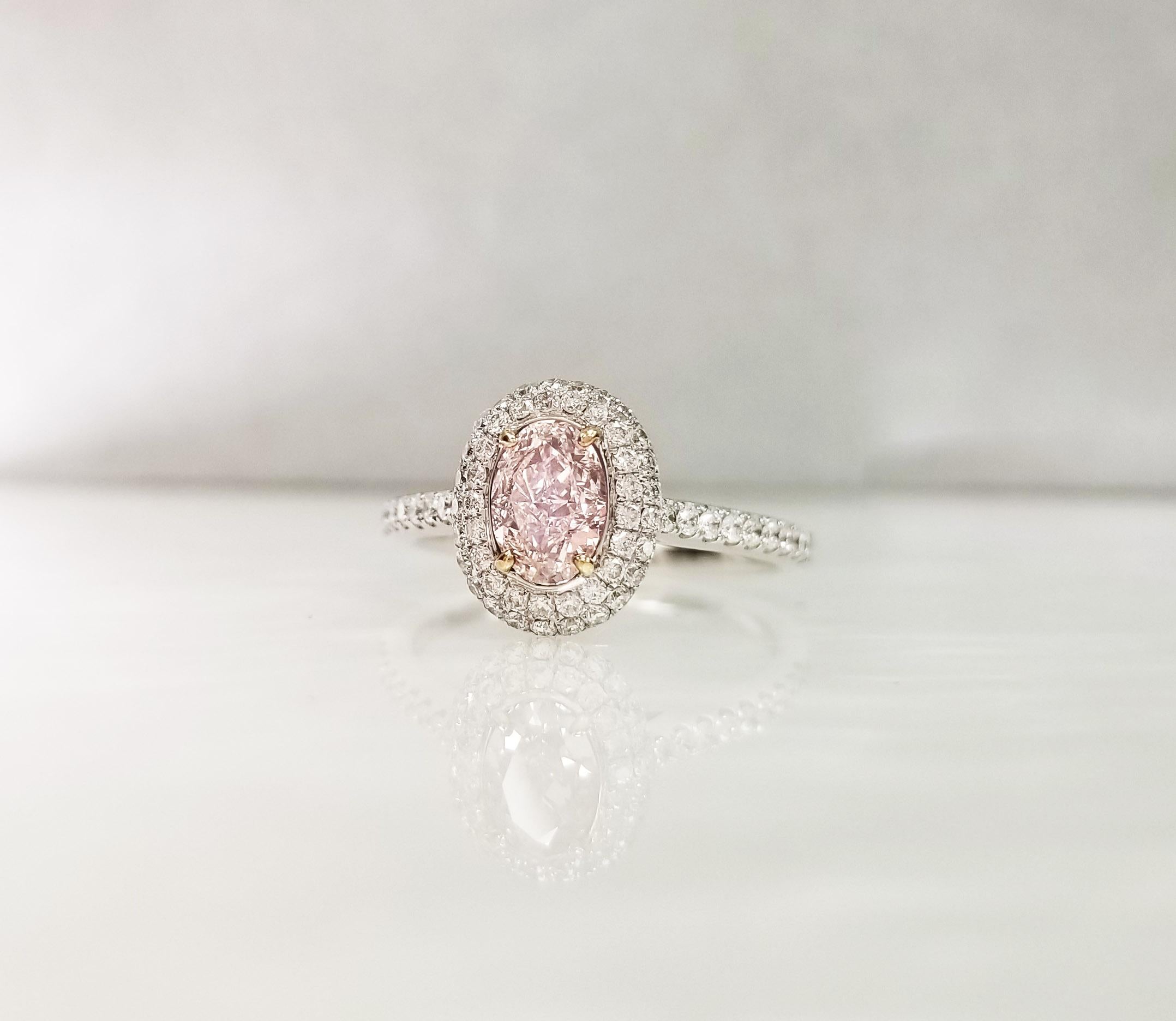 GIA-zertifiziert 0,82 ct Oval Pink Diamond Engagement Halo Ring auf 18k Weißgold Band. Der zentrale rosafarbene Diamant mit der Reinheit VVS1 ist von zwei Reihen runder weißer Diamanten umgeben, die einen Halo-Effekt erzeugen. Die Größe des Rings