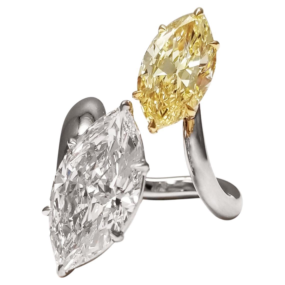 Exquisite style and wearability come with this platinum Diamond ring, presenting a 5-carat white Marquise from the Millennium Collection from DeBeers, an offering from the year 1999. Set next to a Scarselli's Fancy Yellow 3 carat marquise Diamond,