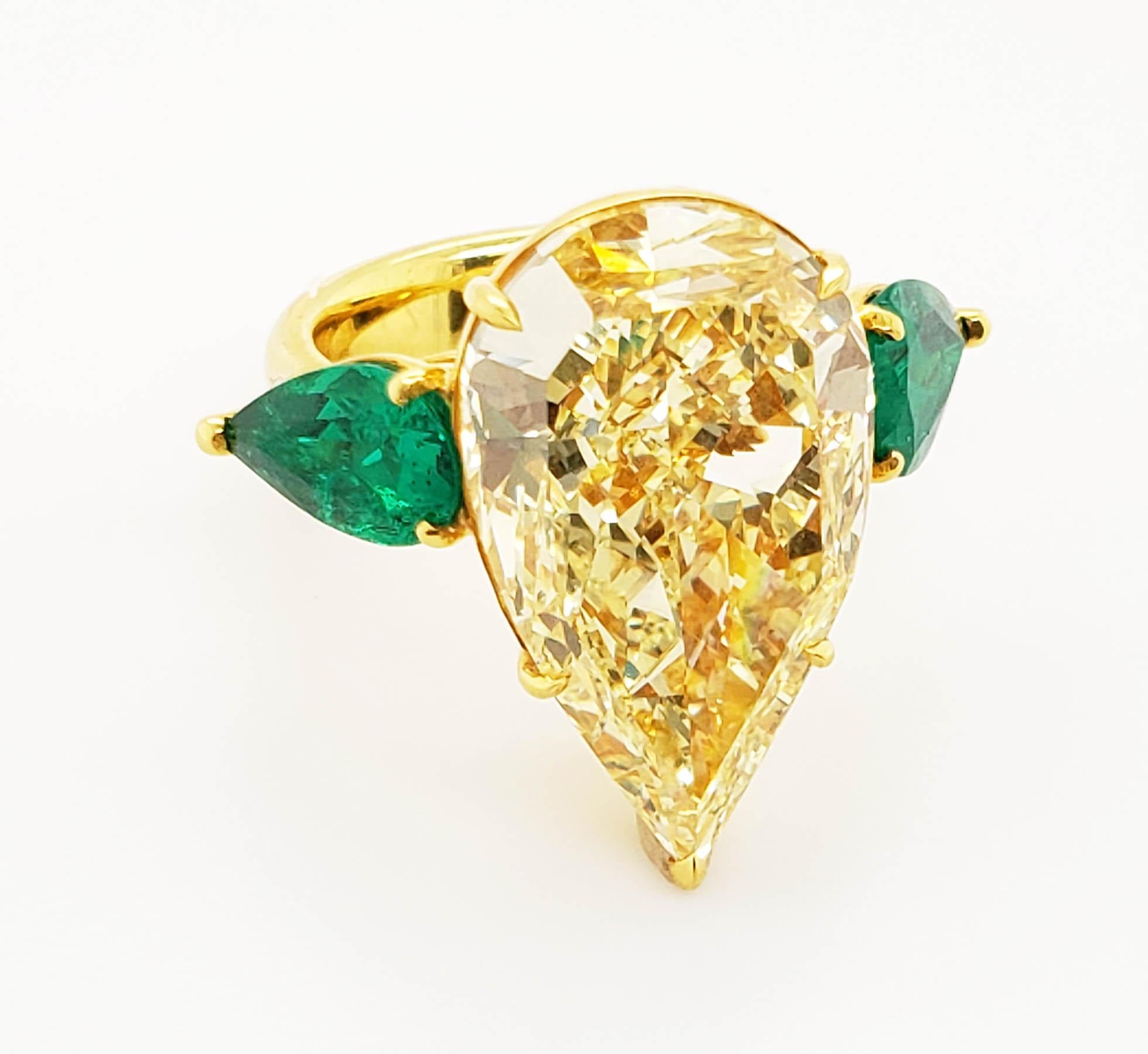 From SCARSELLI, this 13.93 carat Fancy Yellow Pear shape Cut Diamond is GIA Graded VS2 clarity. The diamond is flanked by a pair of pear shape Colombian emeralds 2.38 carats together F-G color VS+ clarity. This ring may be sized with Scarselli to