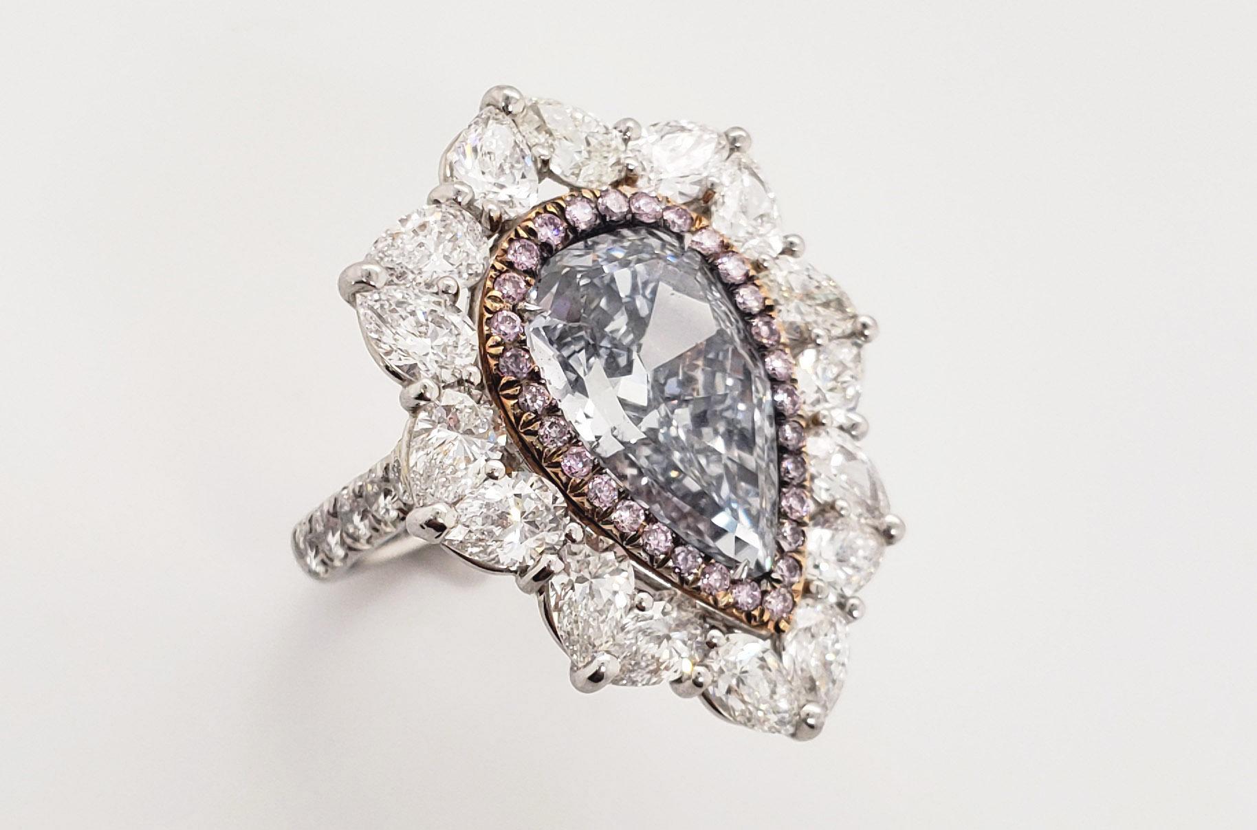 From Scarselli, this extraordinary ring features a large 6 carat Fancy Grayish Blue Pear shaped cut diamond,  VS1 clarity (see certificate picture for detailed stone's information). This gorgeous diamond is set off with fancy pink round cut diamonds