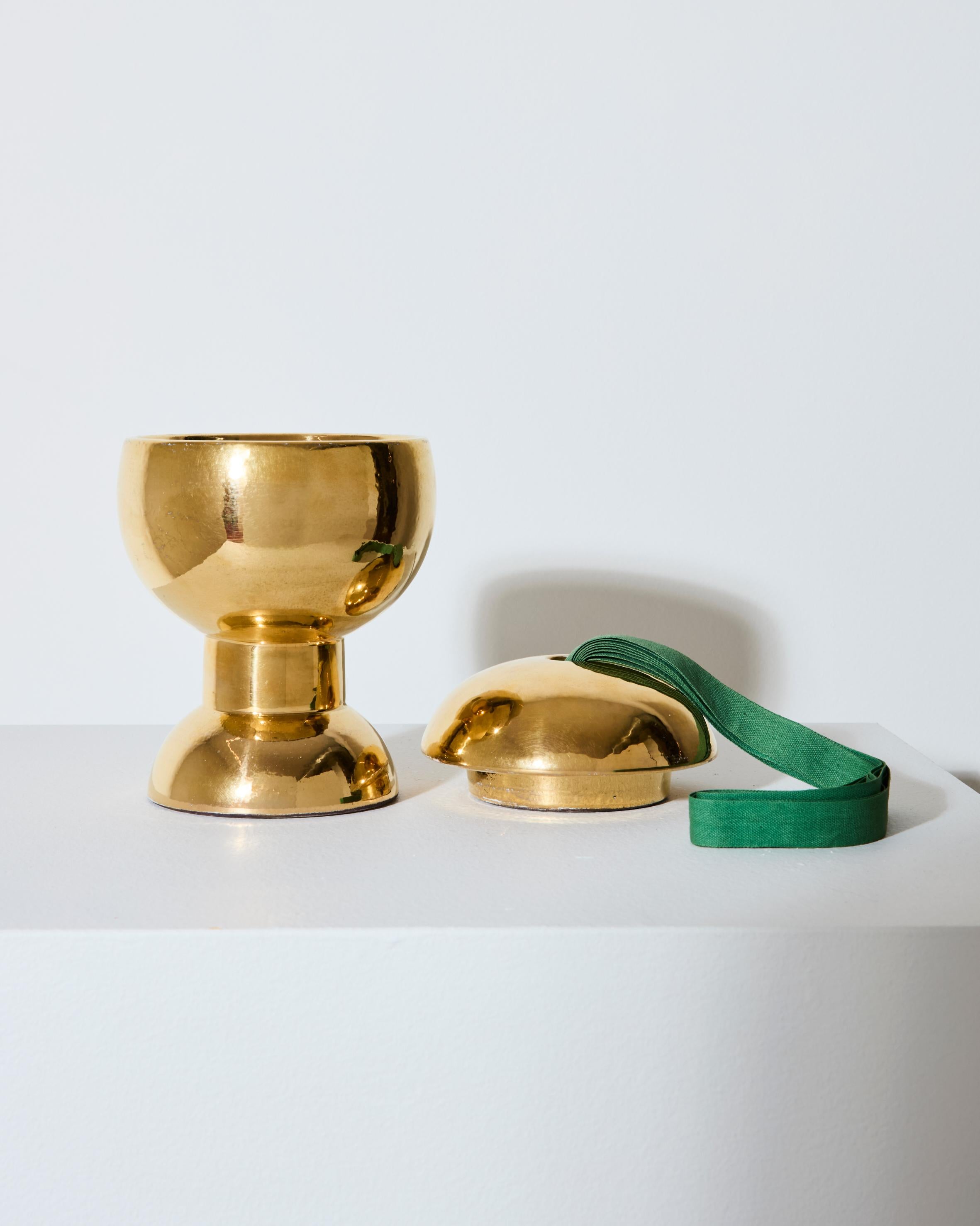 Box with lid No. 387 in gold-colored ceramic with green fabric lace, designed by Ettore Sottsass, Bitossi execution for Il Sestante, c. 1959.
The base bears the inscription 