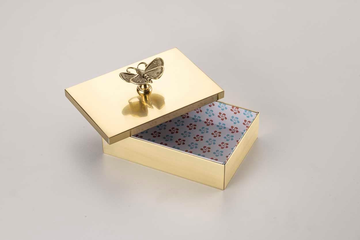 Añada un toque de elegancia a su hogar con nuestra encantadora caja de latón. Perfecto como objeto de almacenaje o decorativo, presenta una encantadora cubierta de papel decorada y un bonito pomo de latón en la tapa. Elija entre varios acabados y