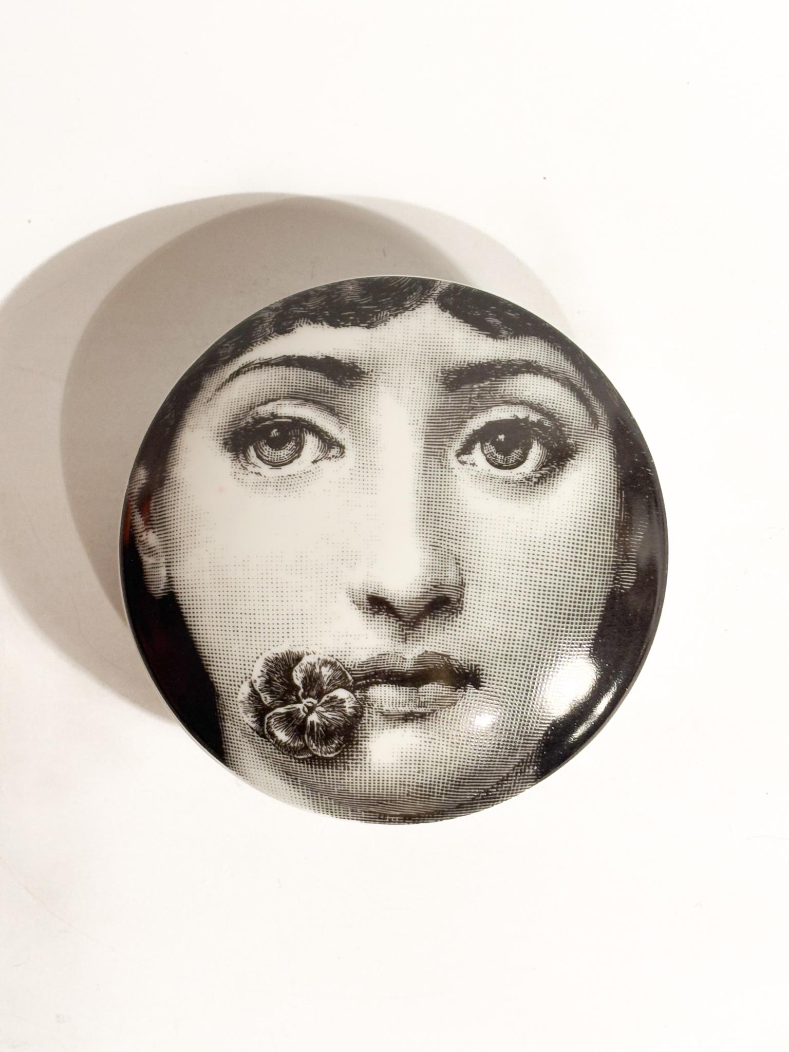 Scatola tonda, n. 137, collezione Tema e Variazioni, realizzata da Fornasetti negli anni '70

Ø cm 10,5 h cm 4

La pièce fait partie de la série iconique 