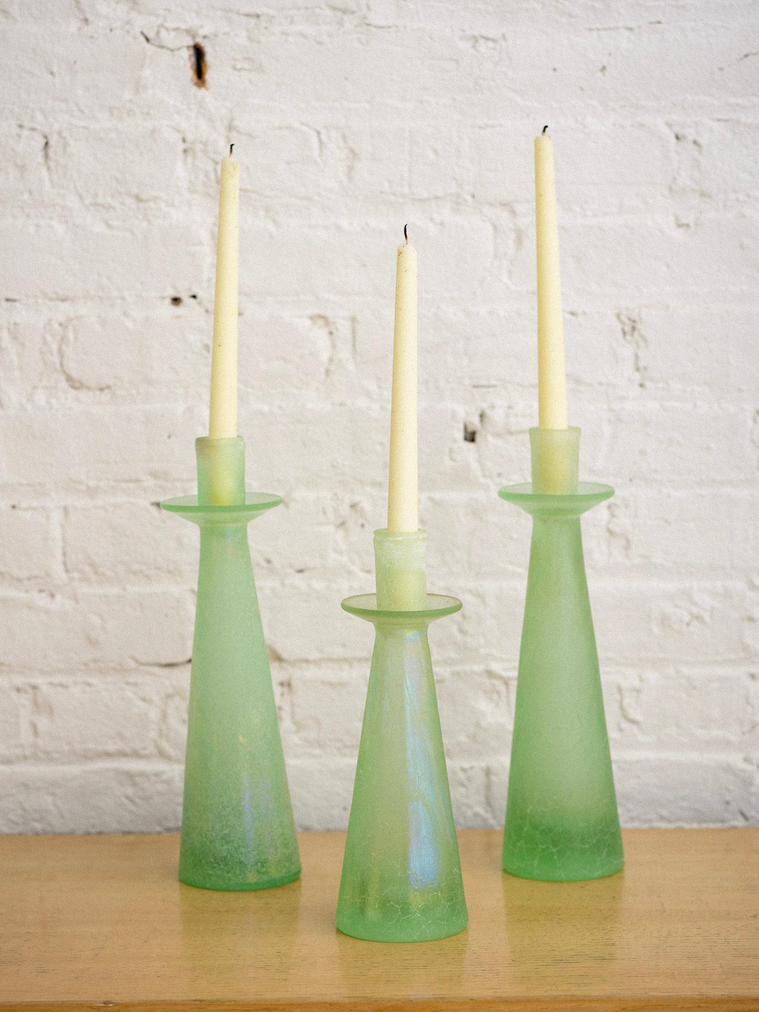 A trio of candle holders in the style of Cenedese. Two larger candle holders and one smaller. Scavo glass featuring a textured iridescent surface.