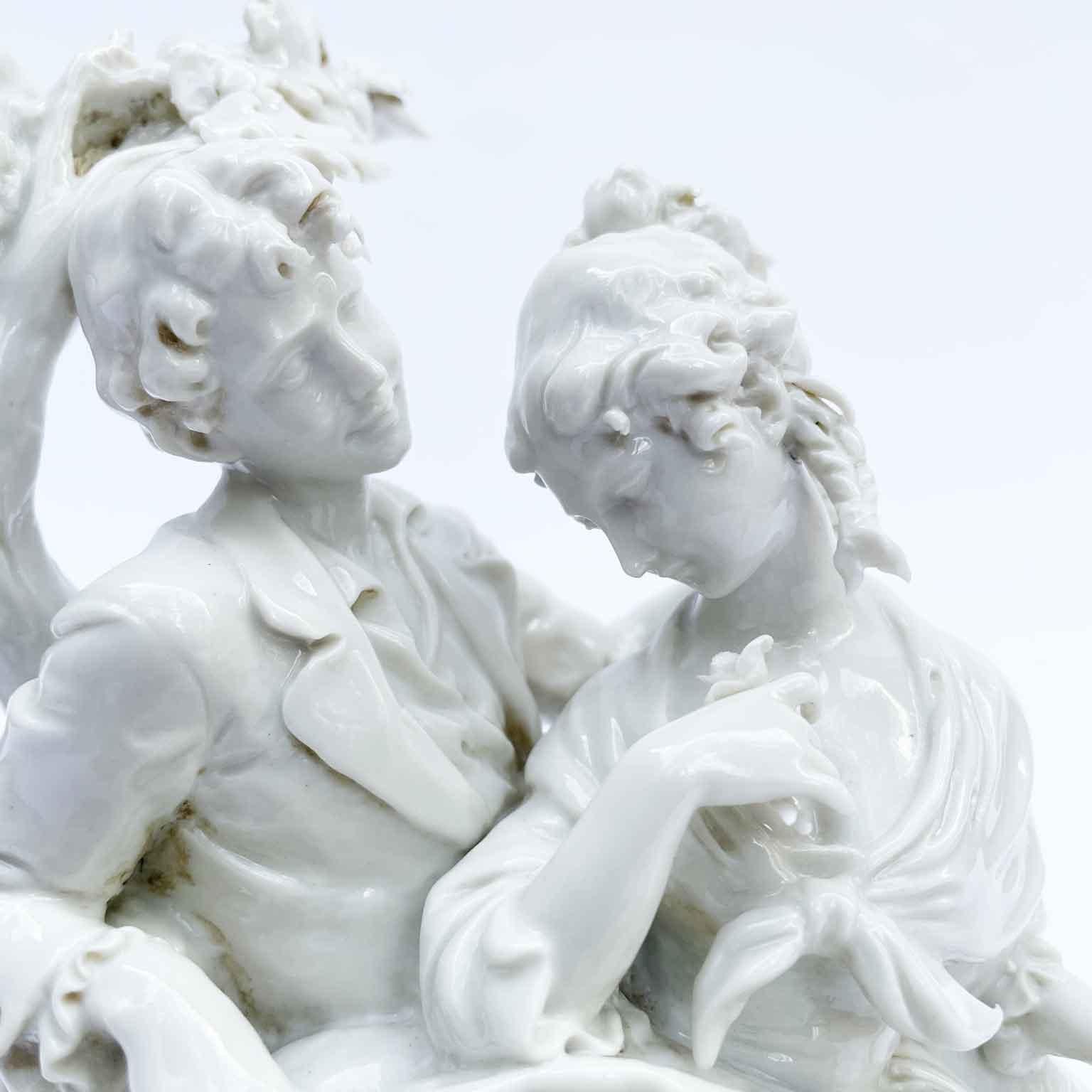 Giuseppe Cappé Scena Amorosa 1960 circa gruppo in porcellana bianca e oro con le figure di due innamorati, una scena galante che raffigura una dama con una rosa in mano, seduta in grembo all'innamorato, con la schiena addossata ad un tronco di