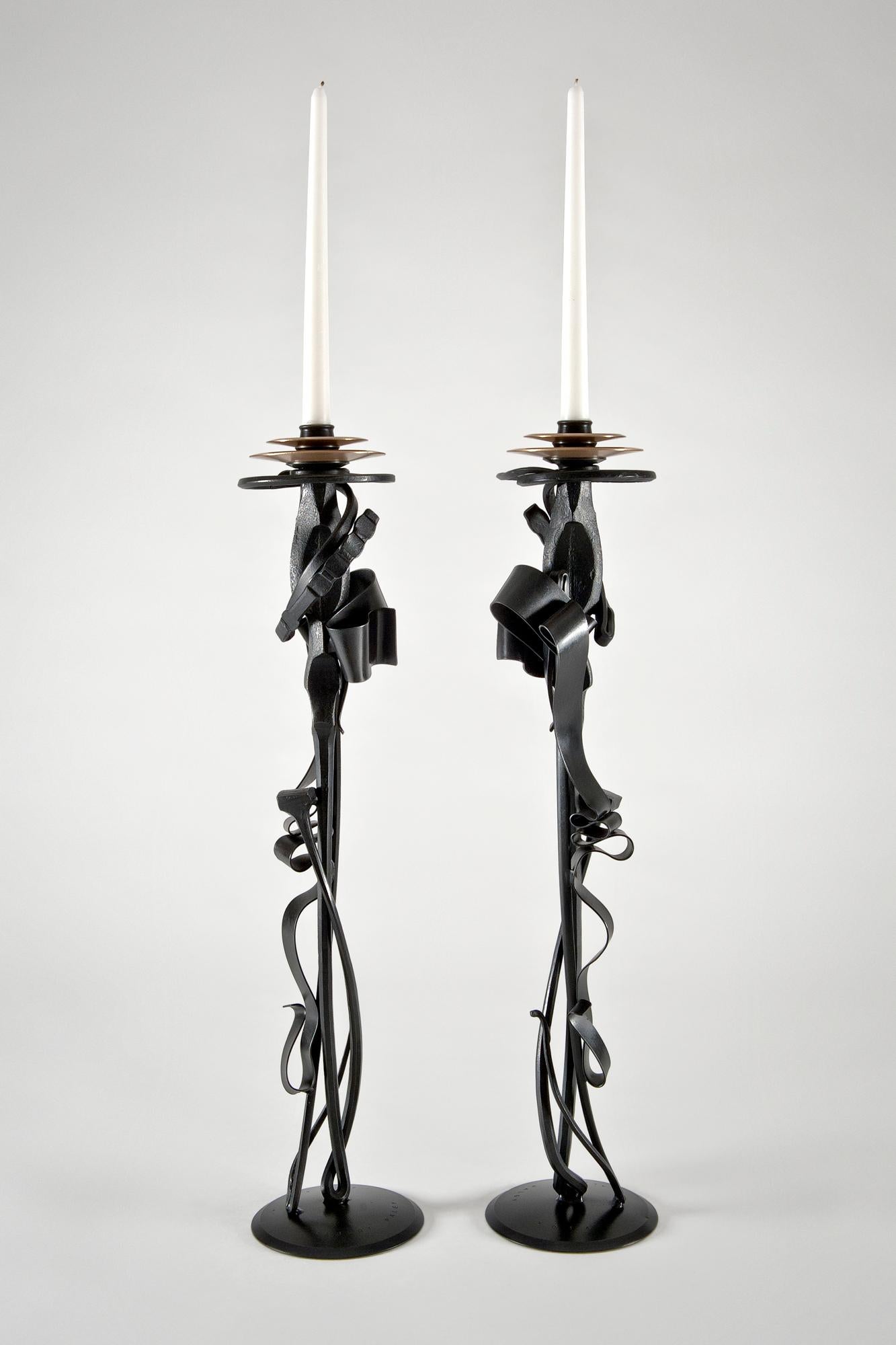 Edition of only 50 sets. handmade in the artist's studio; each varies slightly. Each stamped Albert Paley 2014 on base and numbered on underside. This pair is numbered 70 & 71. Finish is a deep black patina. Double bronze bobeches with satin finish