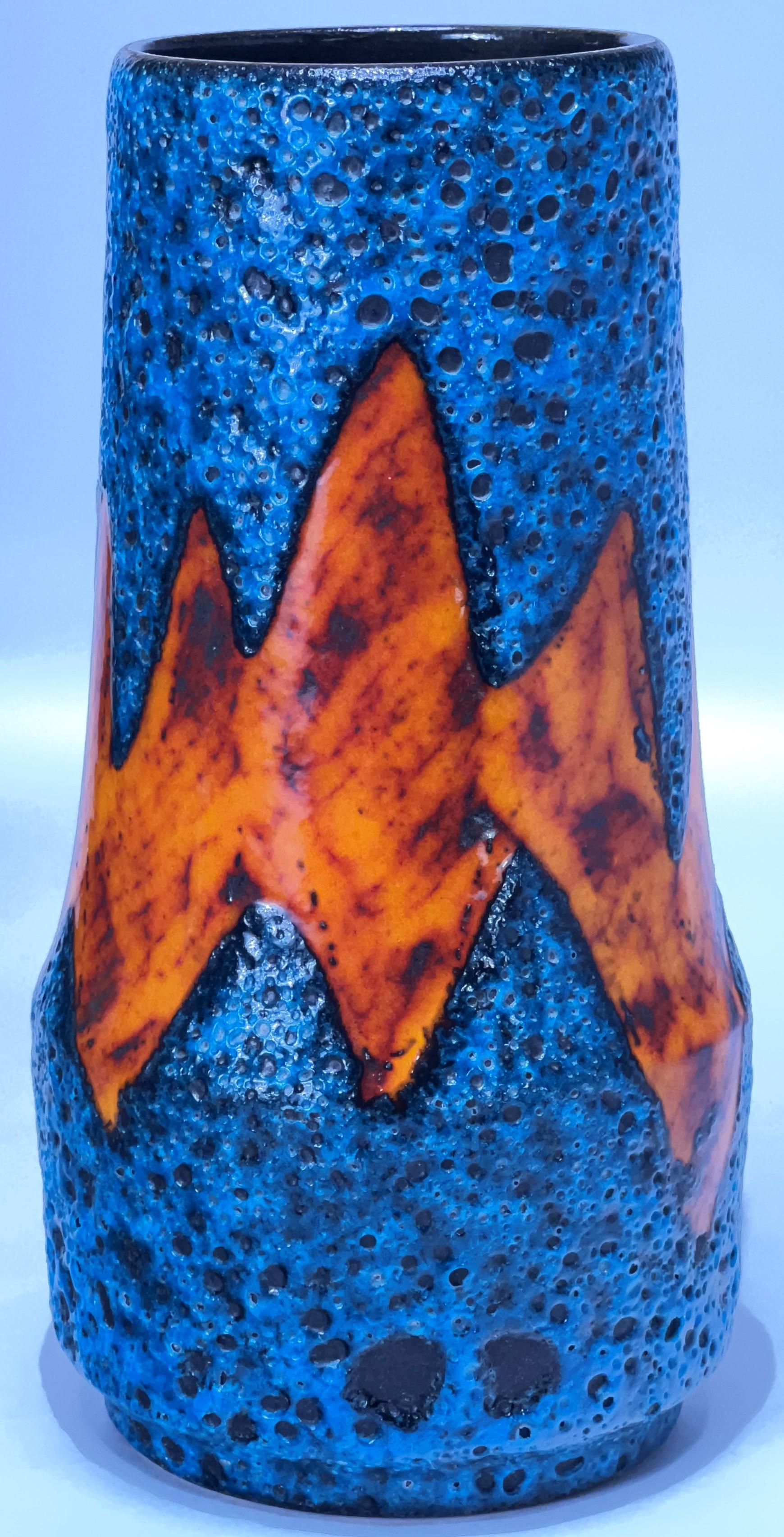 Simply gorgeous peacock blue volcanic orange red lava with a wide flaming zig zag Lightning decor that reminds me of the Lora decor. Although, it also resembles the peaks and troughs of the stock market. In fact, this would make a perfect gift for a