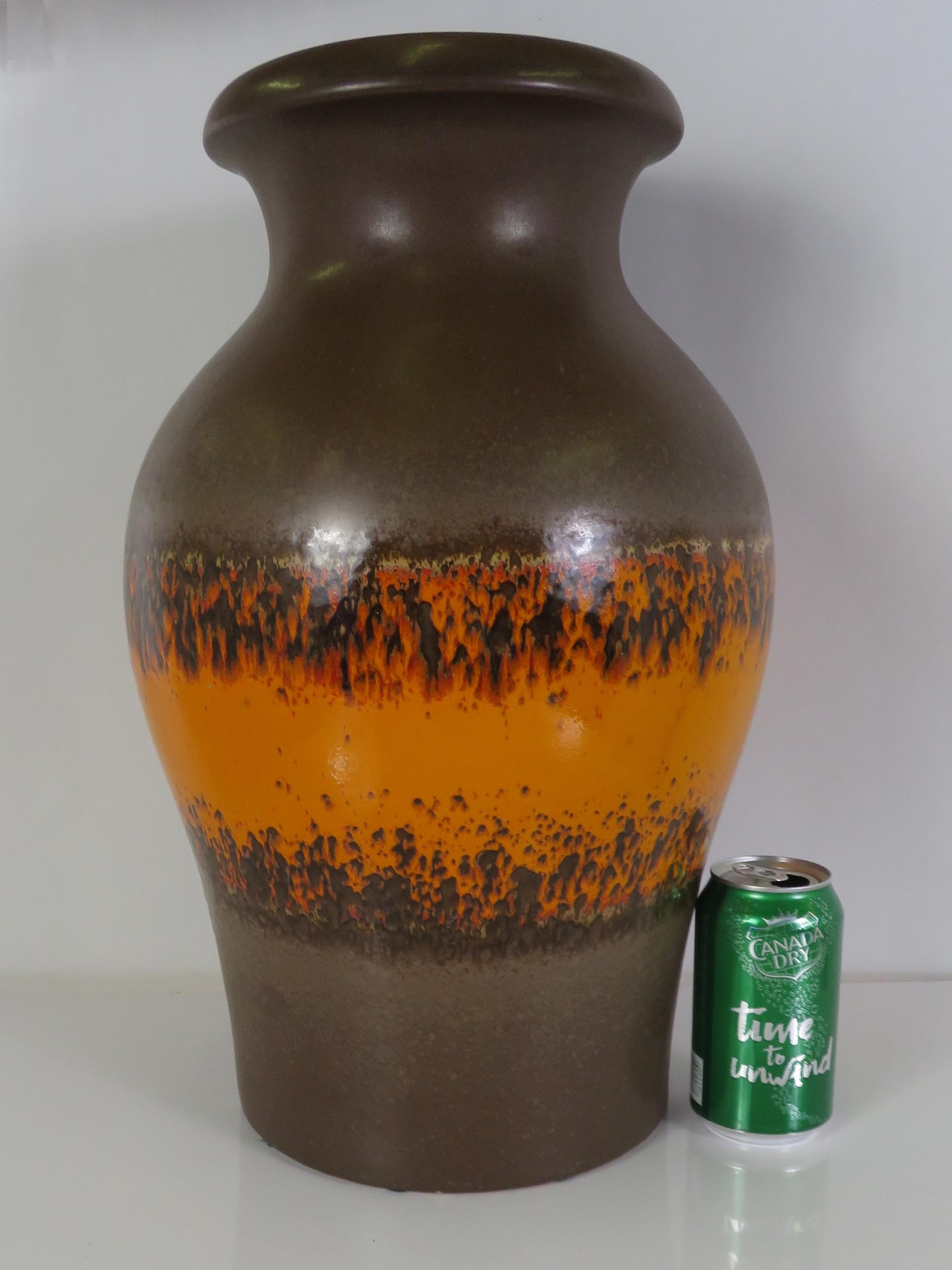 Large and impressive 1960s Mid-Century Modern German lava glaze pottery floor vase from Scheurich pottery. Fat and appealing shape, at once masculine and strong. Designed with an orange lava band on the center on a dark cholate background, the