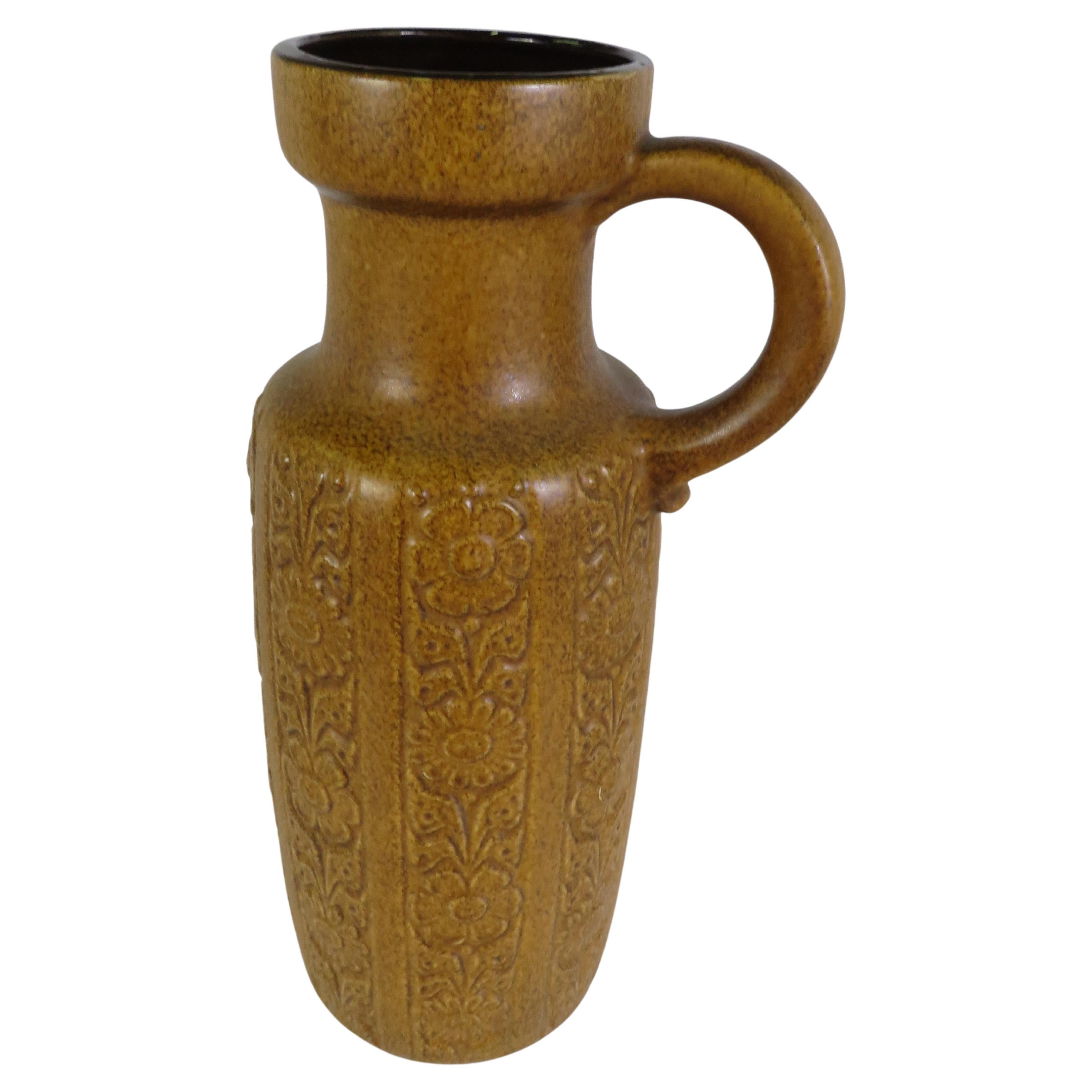 Grand et impressionnant vase à anse de sol ou Krug en poterie allemande du milieu du siècle, provenant de la poterie Scheurich. A l'extérieur, une couleur jaune moutarde tachetée avec un dessin tridimensionnel de fleurs en bandes perpendiculaires et