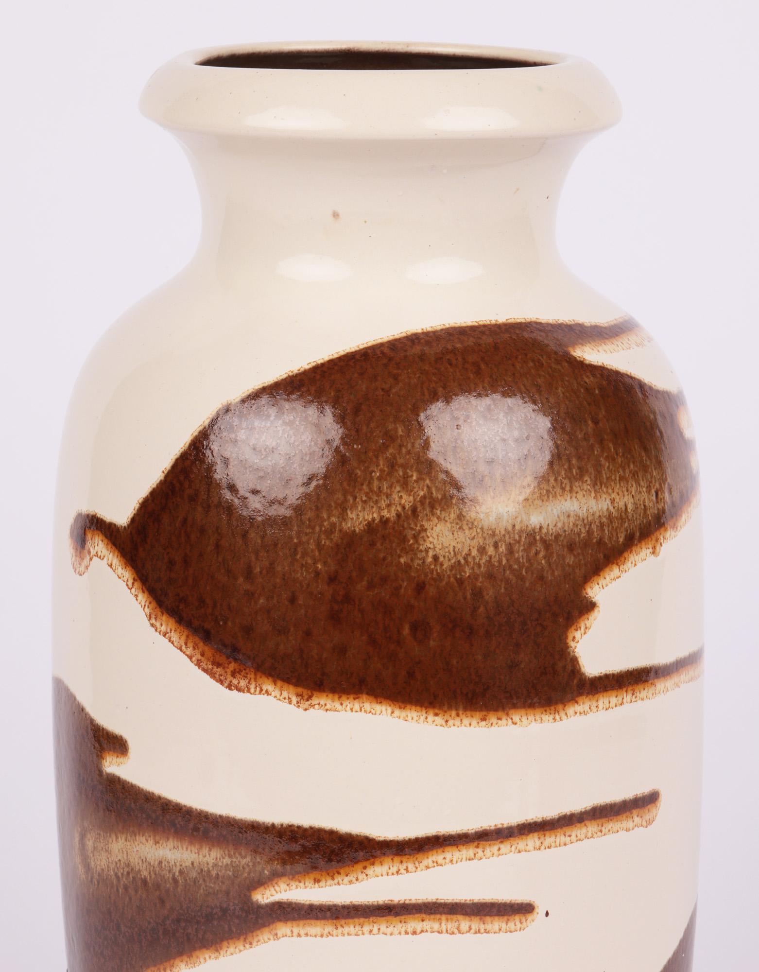 A large and impressive West-German mid-century art pottery vase with abstract designs by Scheurich Keramik dating from around 1960. The tall bulbous vase stands on an unglazed round foot with recessed base and has a pinched neck and shaped top with