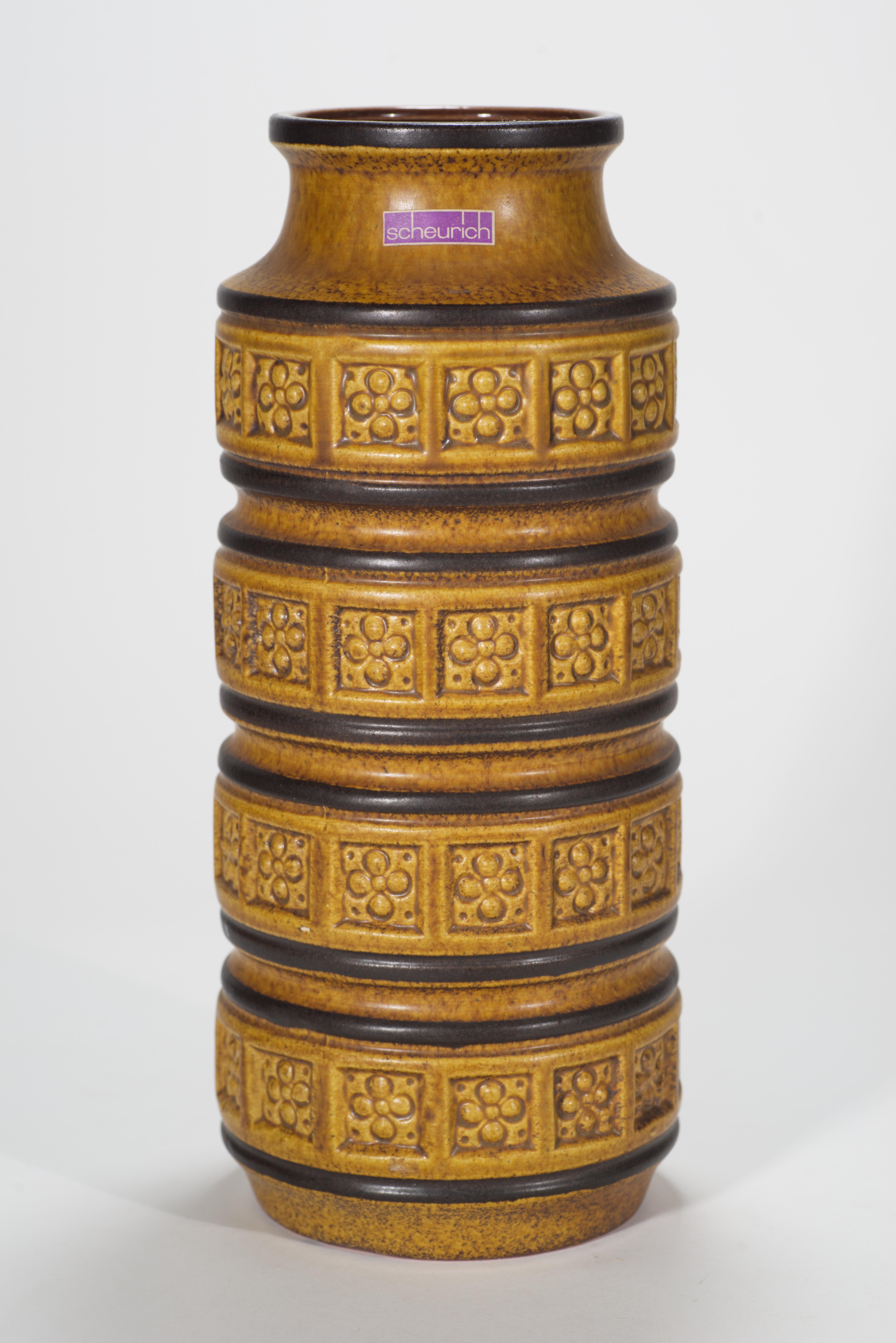 Grande vaso scultoreo in ceramica della Germania occidentale con decoro Foligno modellato, che incorpora bande di fiori stilizzati, e smalto semi-opaco ocra e marrone. Le superfici interne sono smaltate con uno smalto monocromatico lucido color
