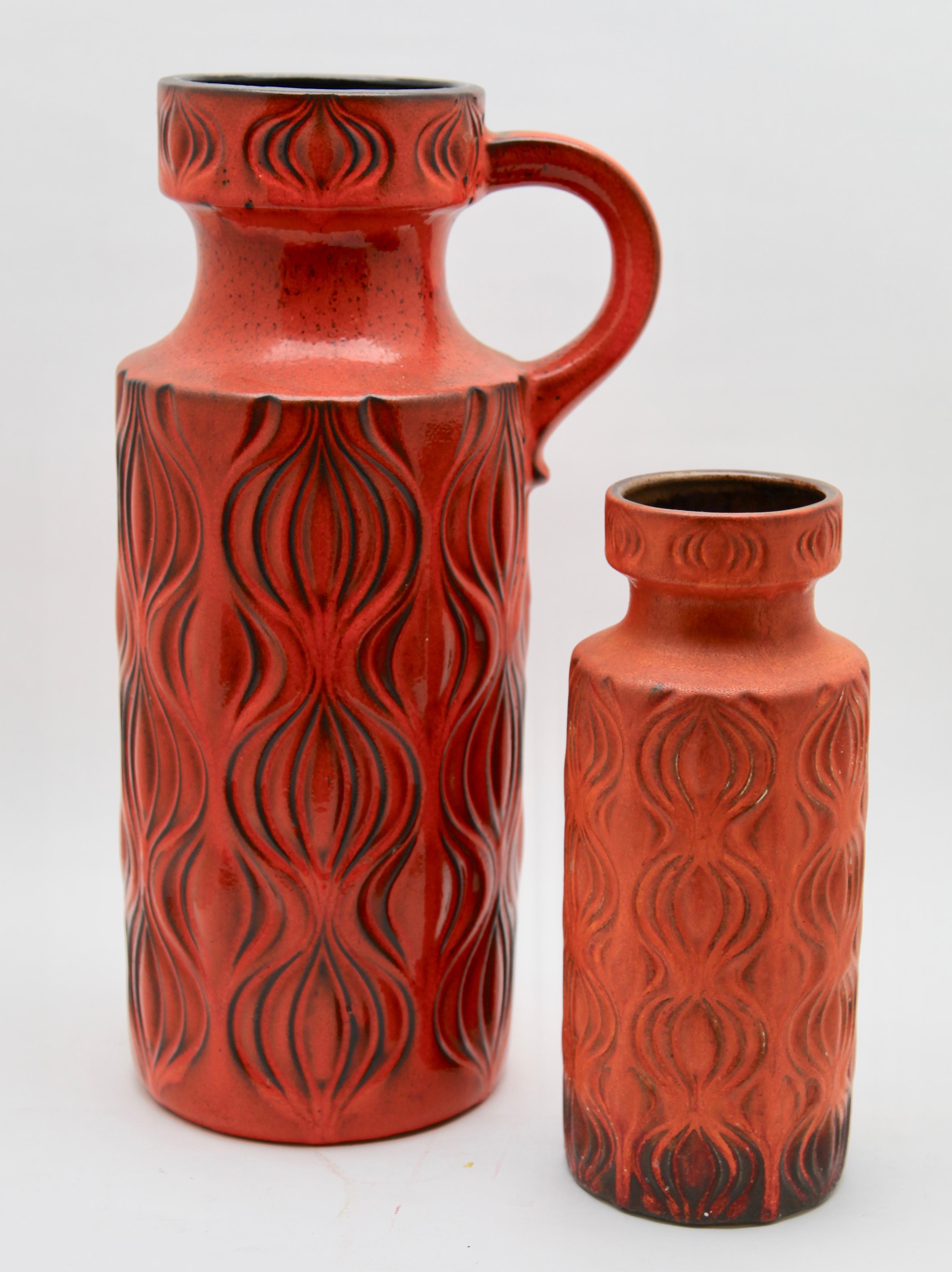 Scheurich vases in orange glaze featuring the indented pattern 'Amsterdam', (so named because the design was inspired by the map of Amsterdam's central canal system).
The larger vase has a glossy version of the glaze and the smaller one a matte