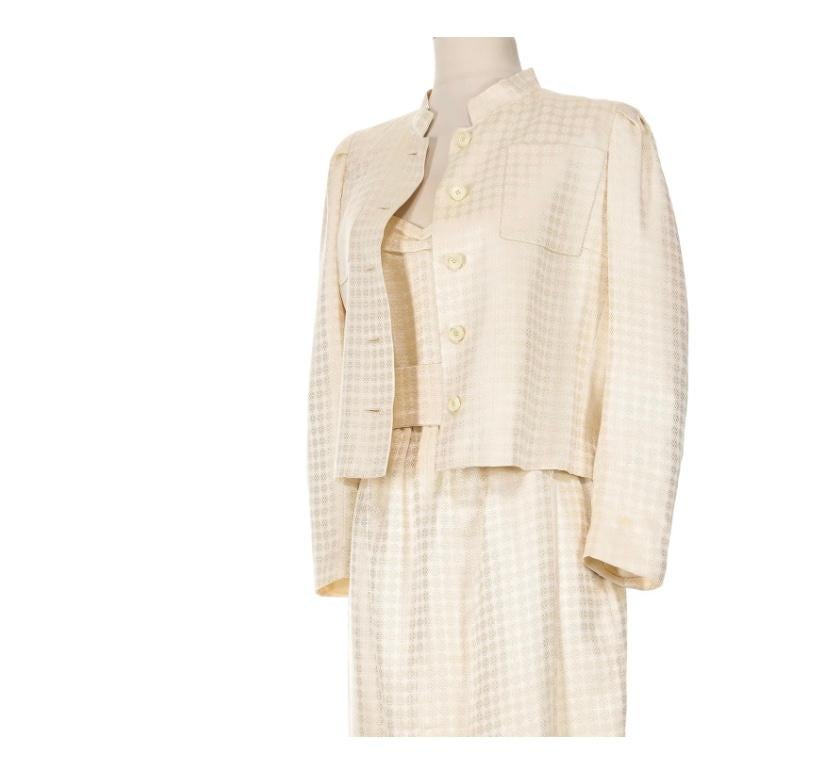 VINTAGE GRACE NY

Entra en la elegancia con este conjunto Schiaparelli, un refinado juego de vestido y chaqueta confeccionado en un exquisito jacquard de seda marfil. La chaqueta presenta un sutil estampado geométrico, botones redondos y cuello mao,