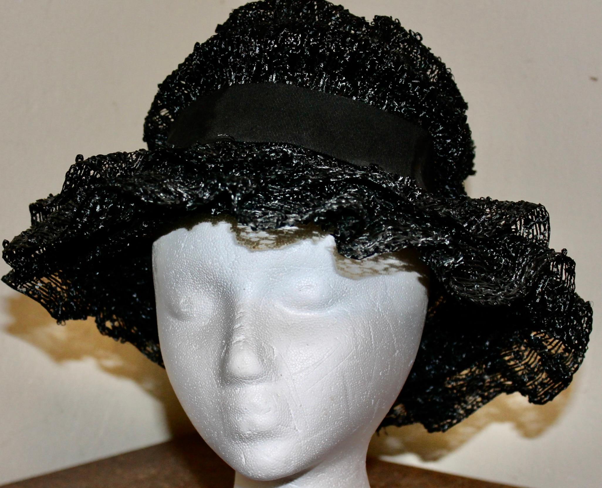Cappello a tesa larga di rafia nera con diametro interno di 4 pollici. Nastro di seta nero. L'altezza del cappello è di circa 6,5 pollici.