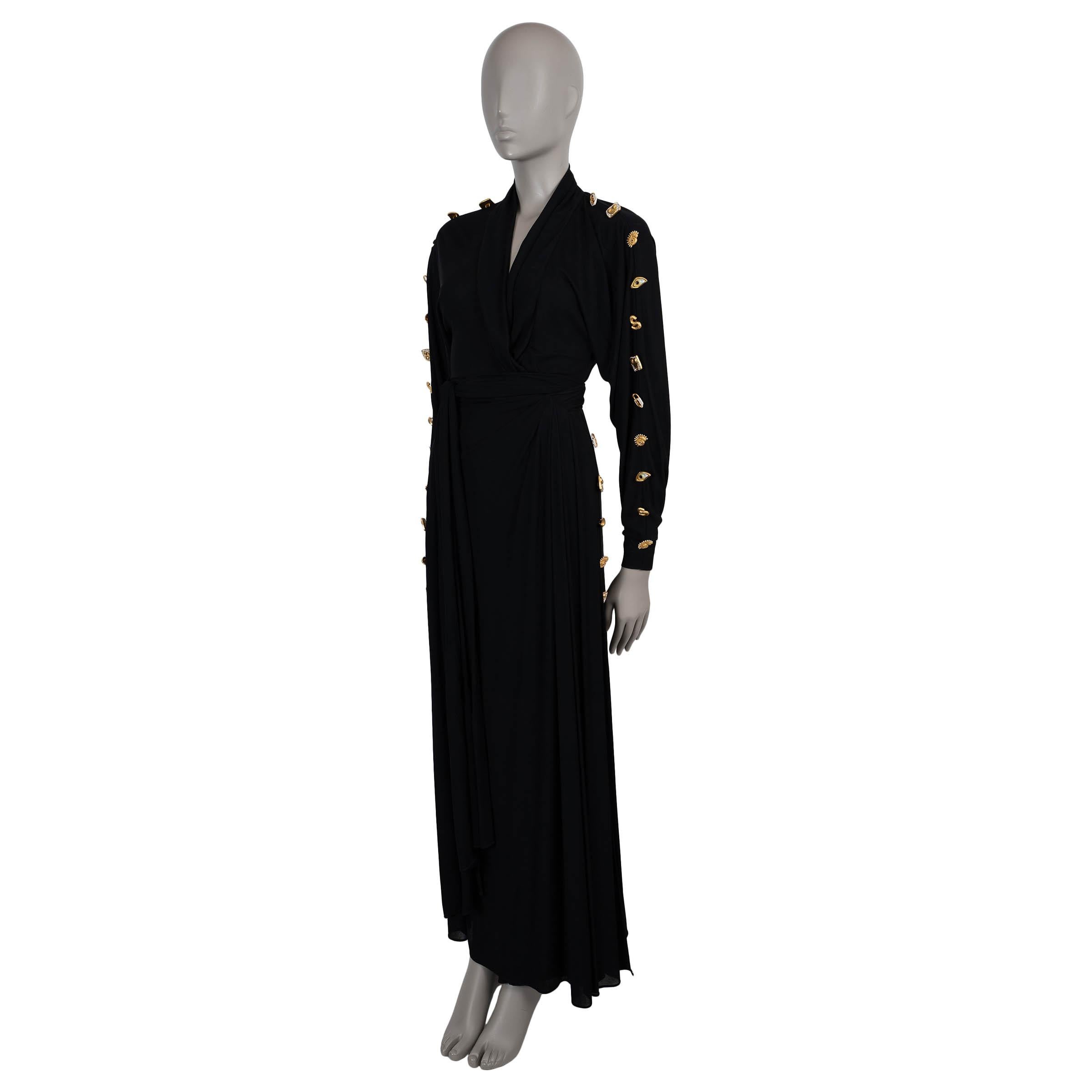 Cette robe du soir en viscose noire (100%), 100% authentique, incarne les codes surréalistes signature de la maison. Conçue avec une silhouette décontractée, elle présente des épaules paddées, des manches chauve-souris spectaculaires, un décolleté