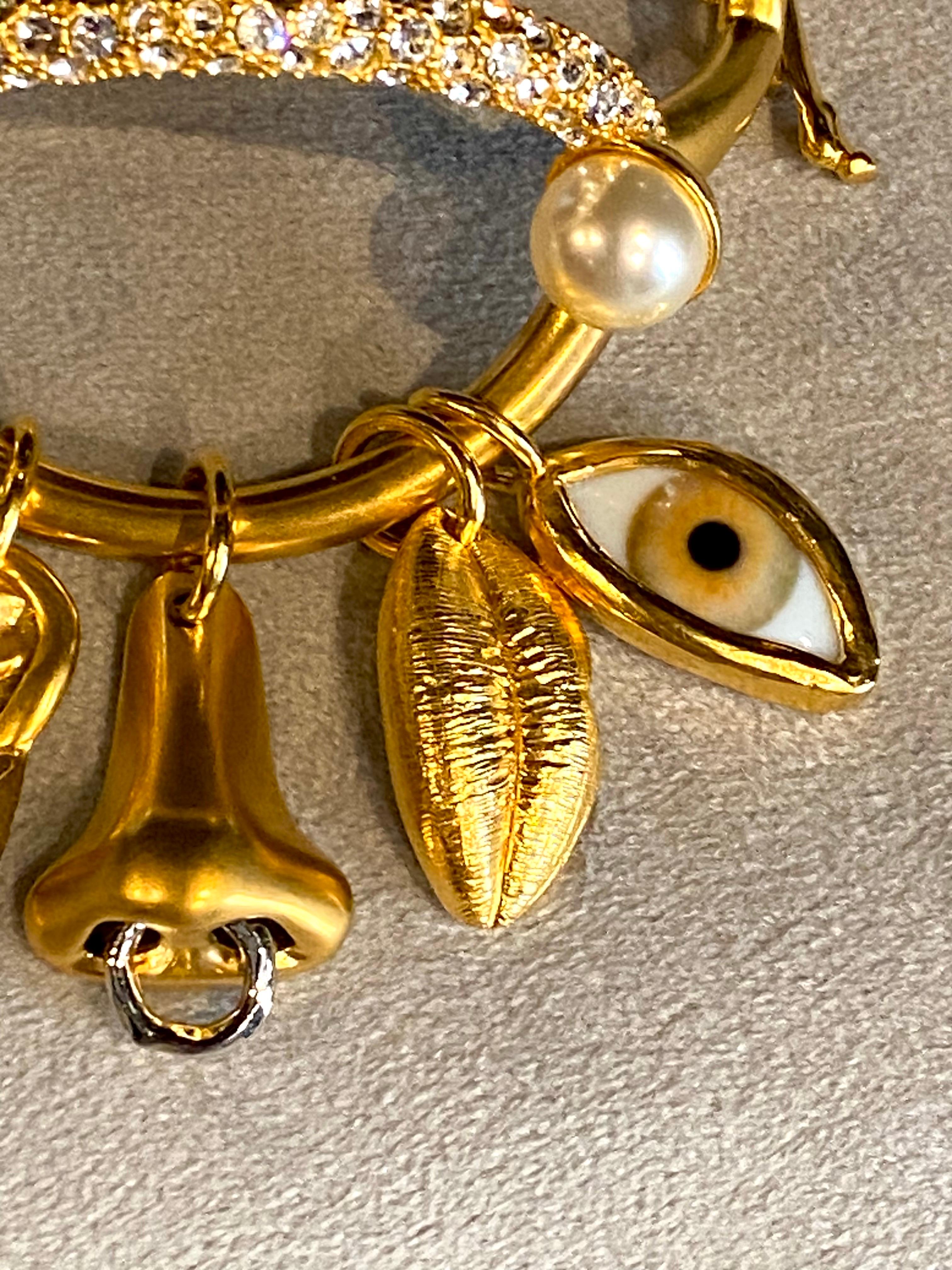 Presented is a striking surrealist Salvatore Dali inspired 'Ode to the Five Senses' charm bracelet from Maison Schiaparelli’s 2021 collection, created under the artistic direction of Daniel Roseberry. Referencing the dreamlike, whimsical style of