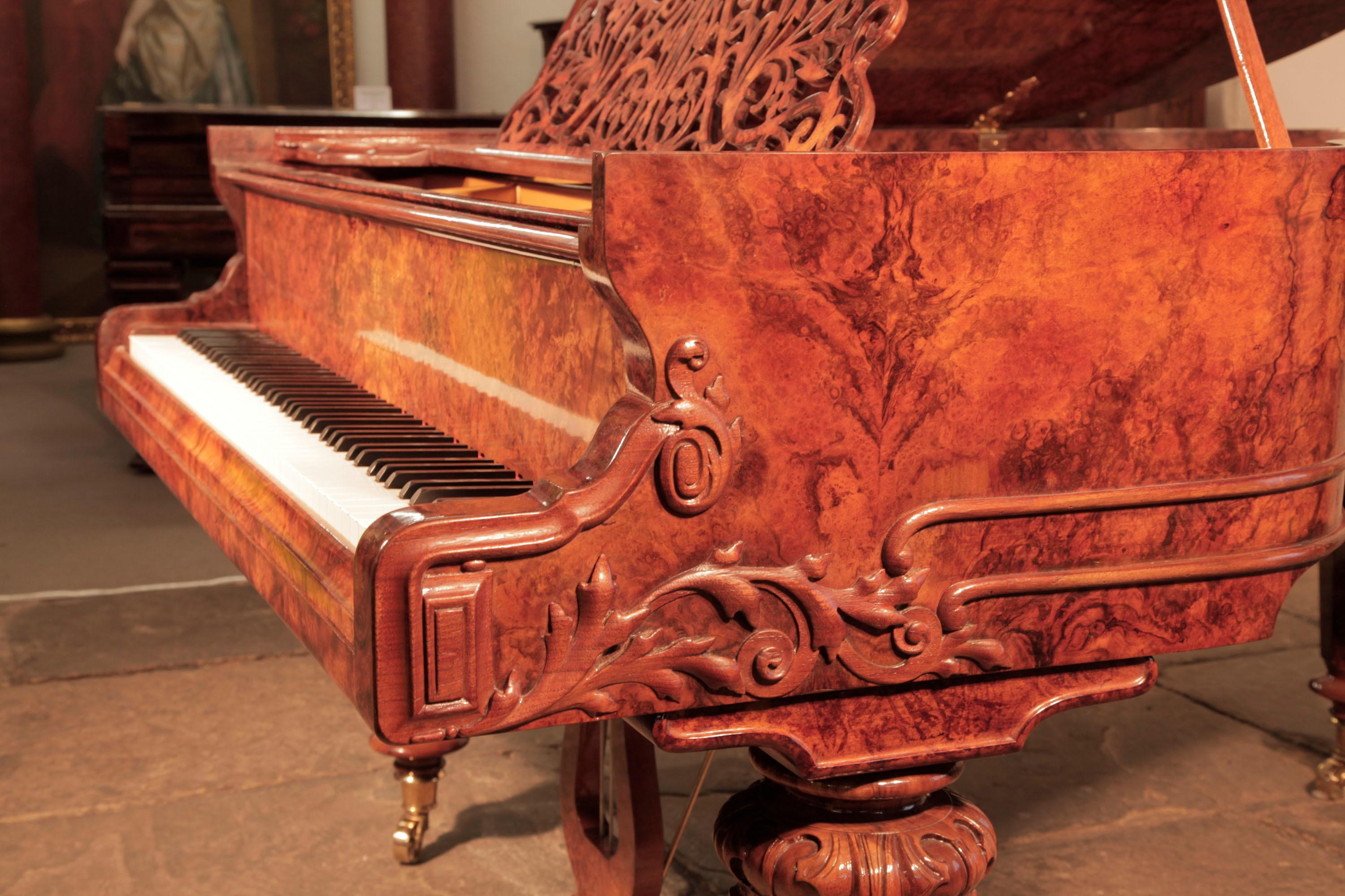 Schiedmayer grand piano with a french polished, burr walnut cabinet. The burr walnut is figured creating rippled patterns in the veneer reminiscent of oil on water.
The serpentine piano cheek features carvings of scrolling foliage, spirals and a