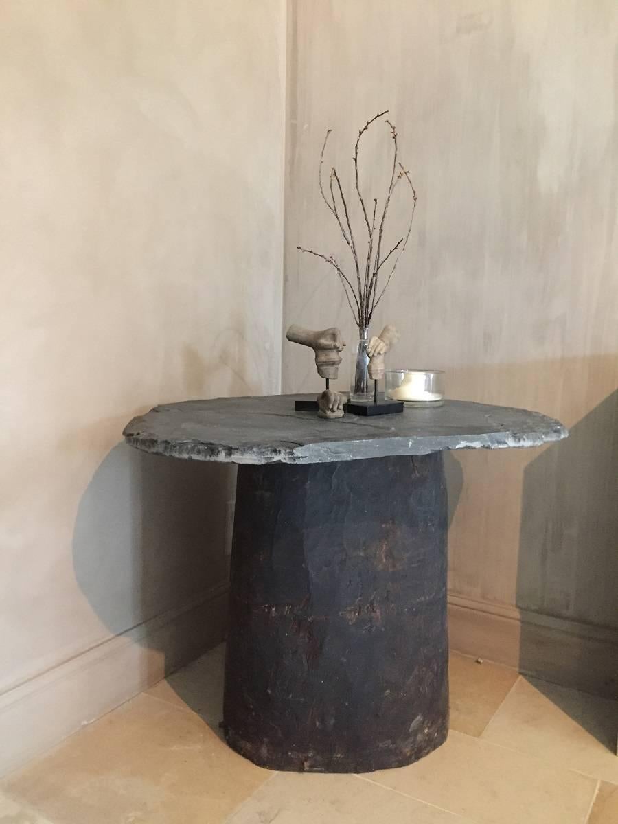 This table was composed as local 19th century craftsmen would do in the French Dordogne region. They used chopped and burned out tree trunks as beehives to produce honey. On top of these trunks slate tops were placed to seal of the containers. When