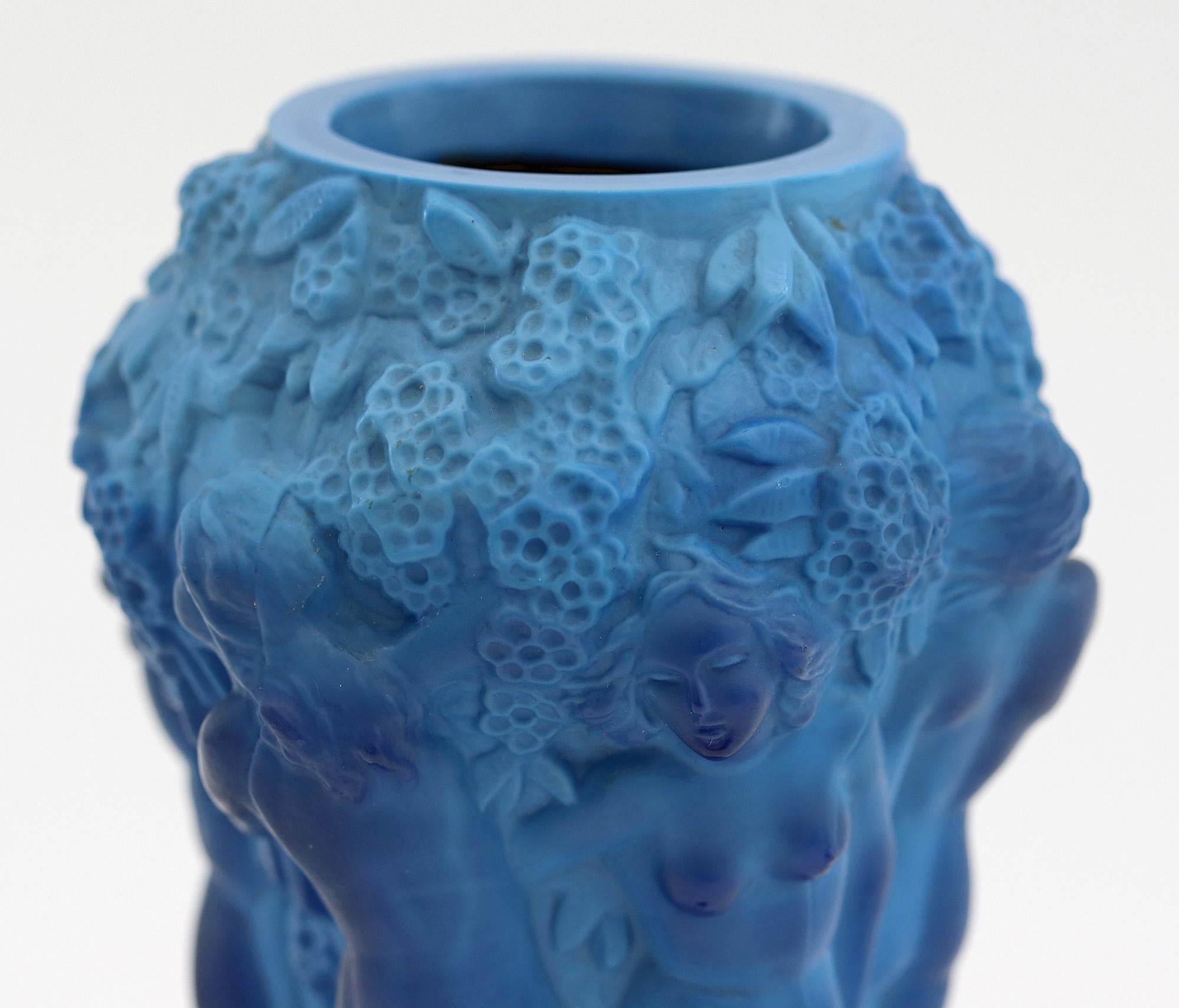 A stylish Art Deco moulded blue glass vase decorated with nudes attributed to Schlevogt and dating from the 1930s. The vase from the Ingrid series portrays six nudes dancing underneath fruiting grape vines standing on a twelve sided base and