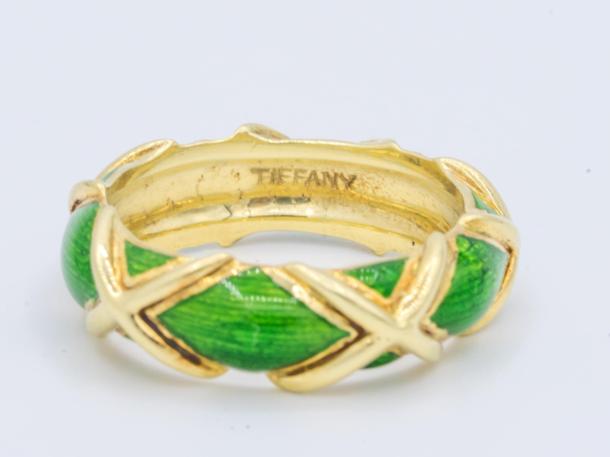 Tiffany & Co. 18k Gold 'X' and Green Enamel design Circa 1960's

Brand: Tiffany & Co.
Ring Size 6
Width: 6.5 mm
Signed: TIFFANY 
Stamped: 18K

Circa 1960's
Condition: Pre-Owned, Minor gold discoloration inner shank,  Enamel in excellent condition,