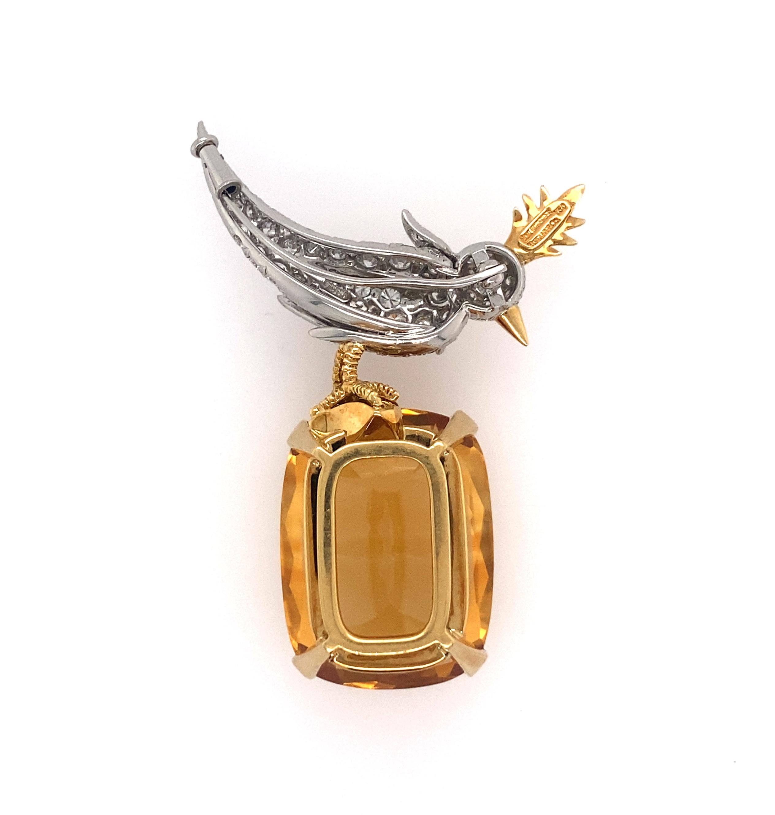 18 Karat Gold, Platinum, Citrine, Diamond and Ruby 'Bird on a Rock' Brooch, Tiffany Schlumberger 
with a cushion-cut citrine weighing approximately 55.00 carats, topped by a bird set with round diamonds weighing approximately 2.75 carats, completed