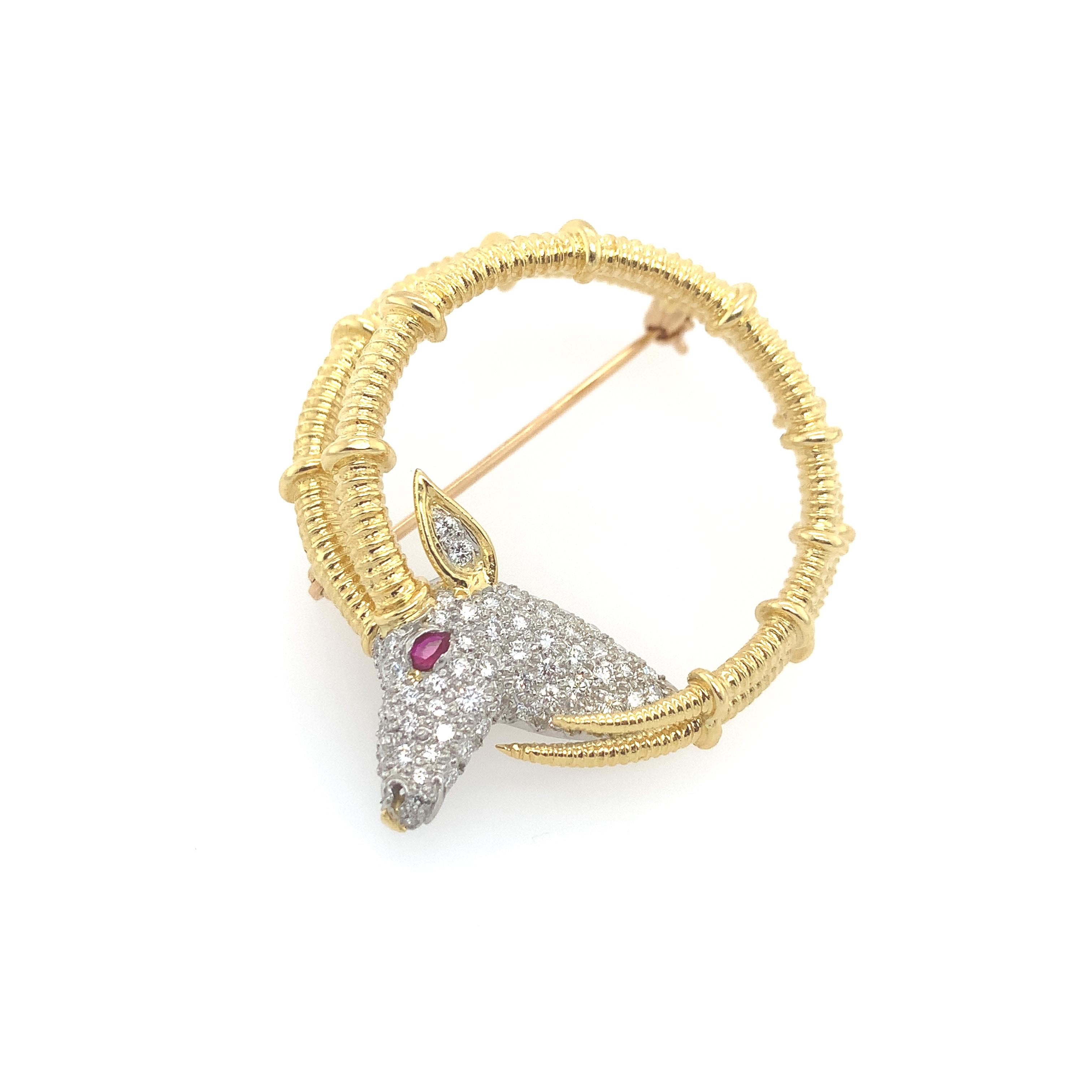 Iconic Ibex ram head pin designed by Jean Schlumberger for Tiffany & Co. Inspired by the majestic beauty of the natural world, this 18K yellow gold and platinum brooch is set with an estimated .87 carats of round brilliant-cut diamonds. Adorned with