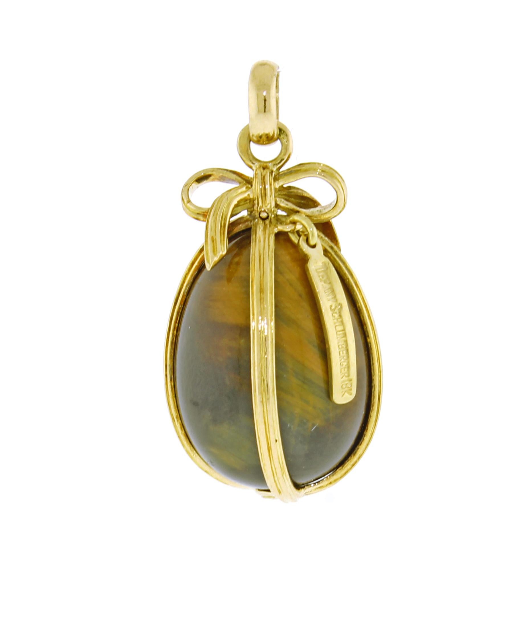 From  Jean Schlumberger his large Tiger's eye caged egg charm.
♦ Designer: Jean Schlumberger
♦ Metal: 18 karat
♦ Gem stone: Tigers eye
♦ Circa 2003
♦ Size 35mm X18mm
♦ Packaging: Tiffany & Co box and pouch
♦ Condition: Excellent , pre-owned
♦ Price: