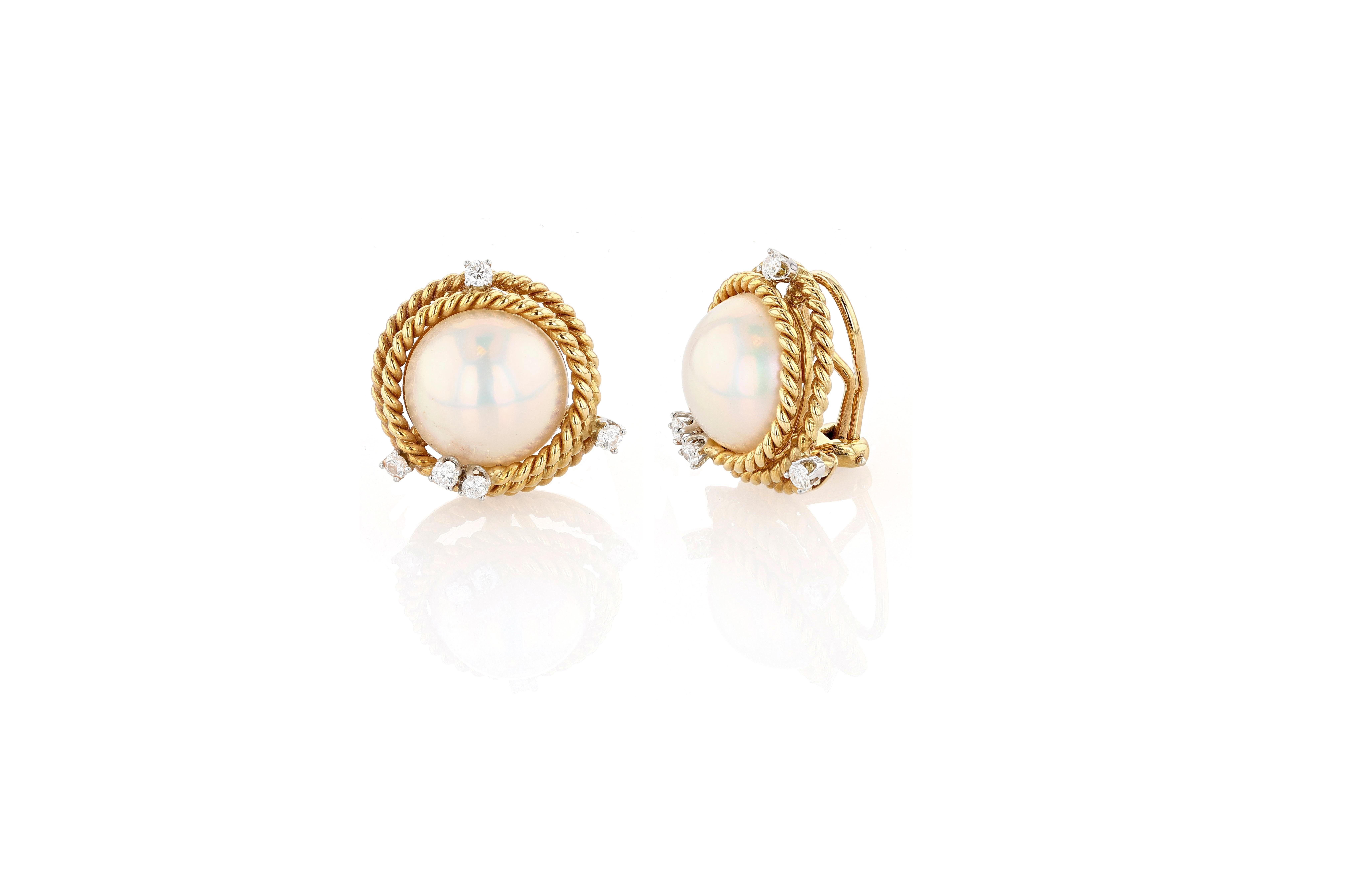 A rare and highly coveted pair of 18 karat gold, mabe pearl, and diamond ear clips by Jean Schlumberger for Tiffany & Co. The ear clips each center a large mabe pearl, encircled romantically in spirals of roped gold, each of these ropes set at