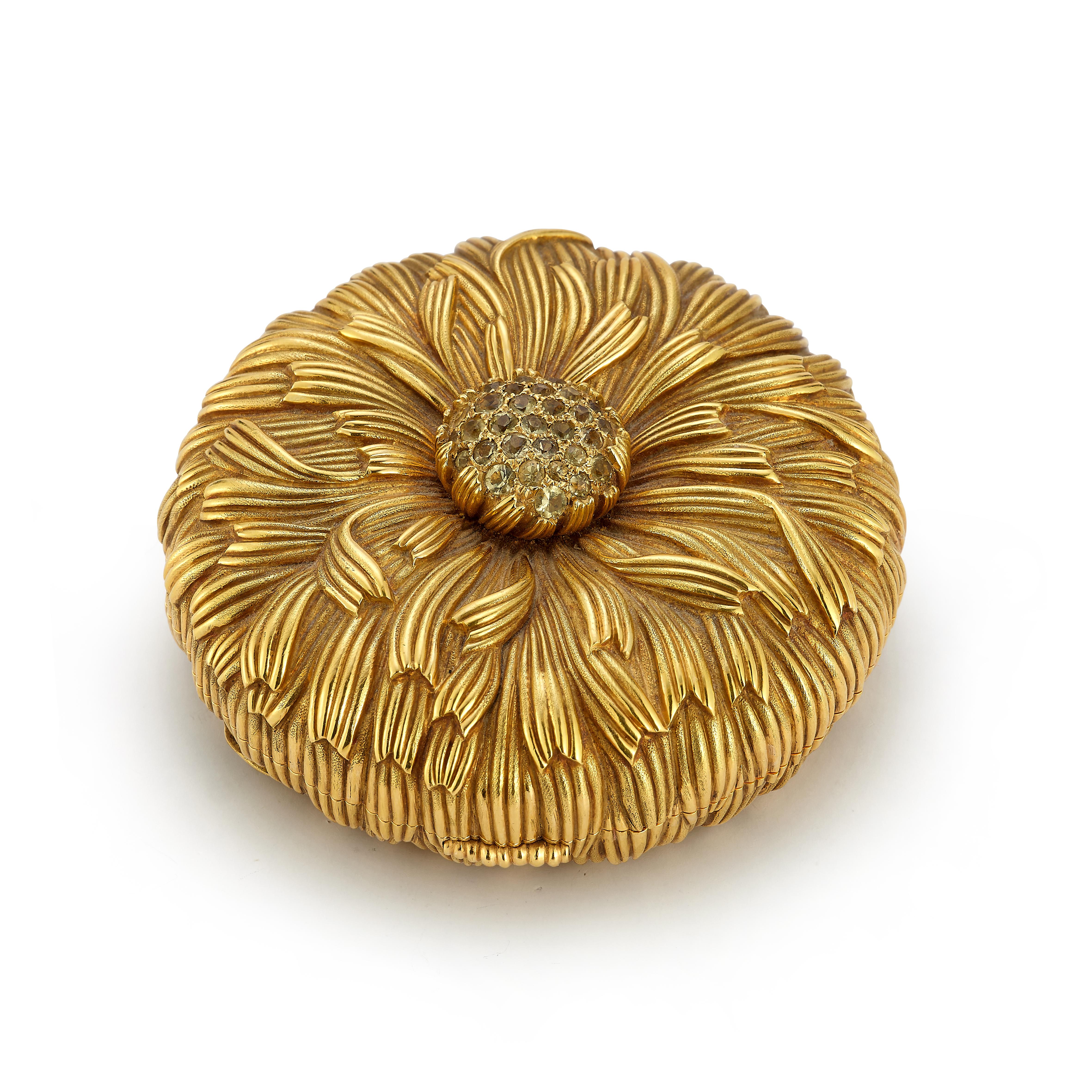 Schlumberger for Tiffany & Co. Yellow Sapphire & Gold Floral Compact Mirror

An 18 karat textured yellow gold compact mirror in the design of a flower set with a cluster of round yellow sapphires in the center. This compact contains a mirror, powder