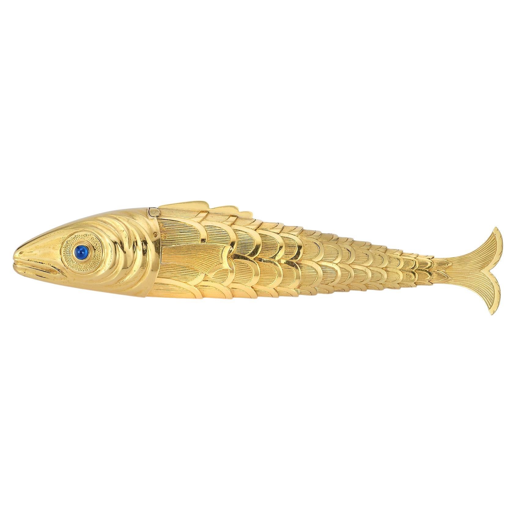Schlumberger Goldfisch-Feuerzeug
Hergestellt ca. 1939.  
Ein beweglicher Goldfisch mit strukturierten Goldschuppen, besetzt mit einem Cabochon-Saphir und einem Rubin als Augen,
18k Gelbgold. 
Der Kopf, der sich aufklappen lässt, um einen
