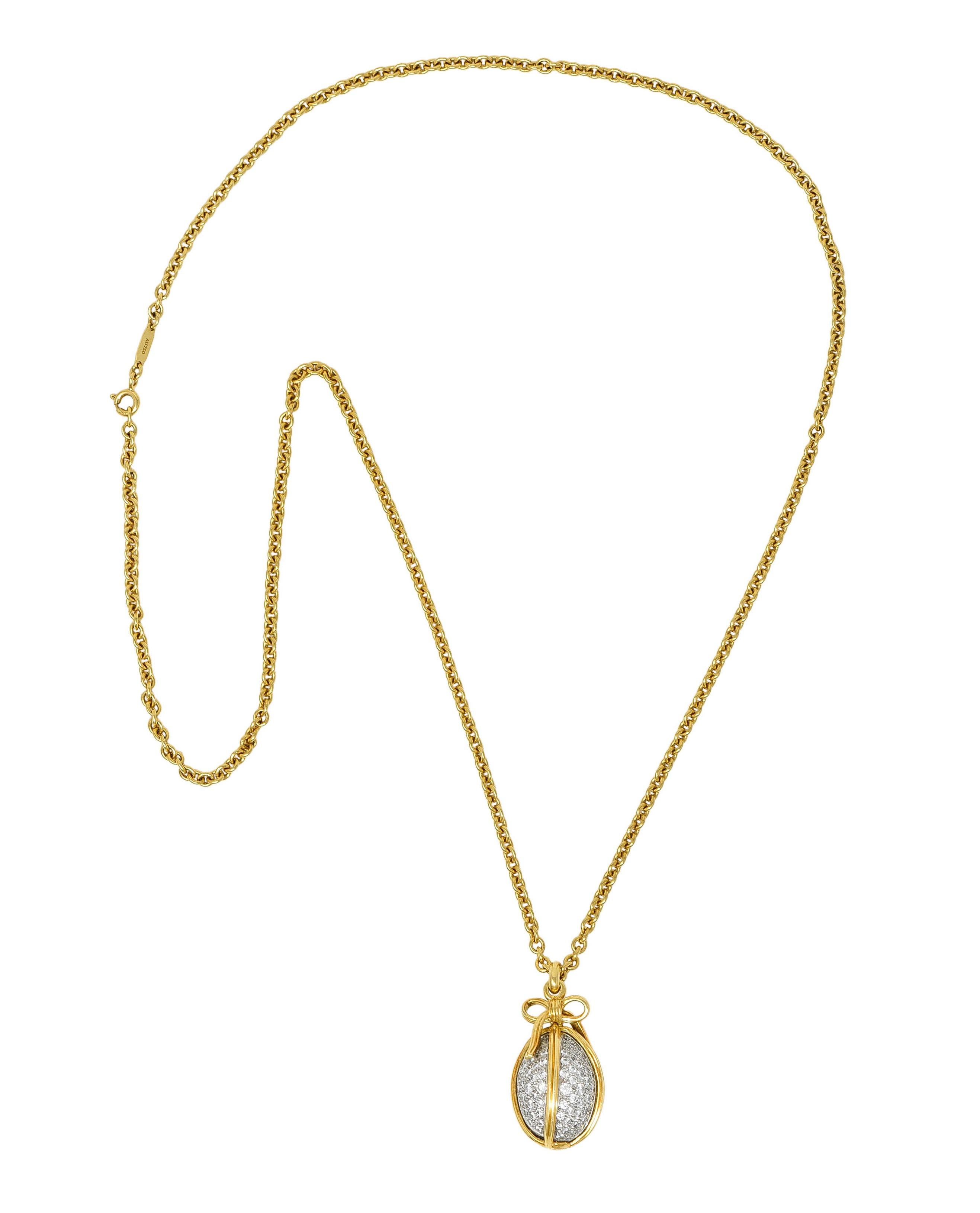 Necklace features an egg shaped platinum pendant

Encompassed by a yellow gold ribbon motif that tops as a bow

Egg is pavè set throughout by round brilliant cut diamonds

Weighing in total approximately 2.75 carats with F/G color and VS