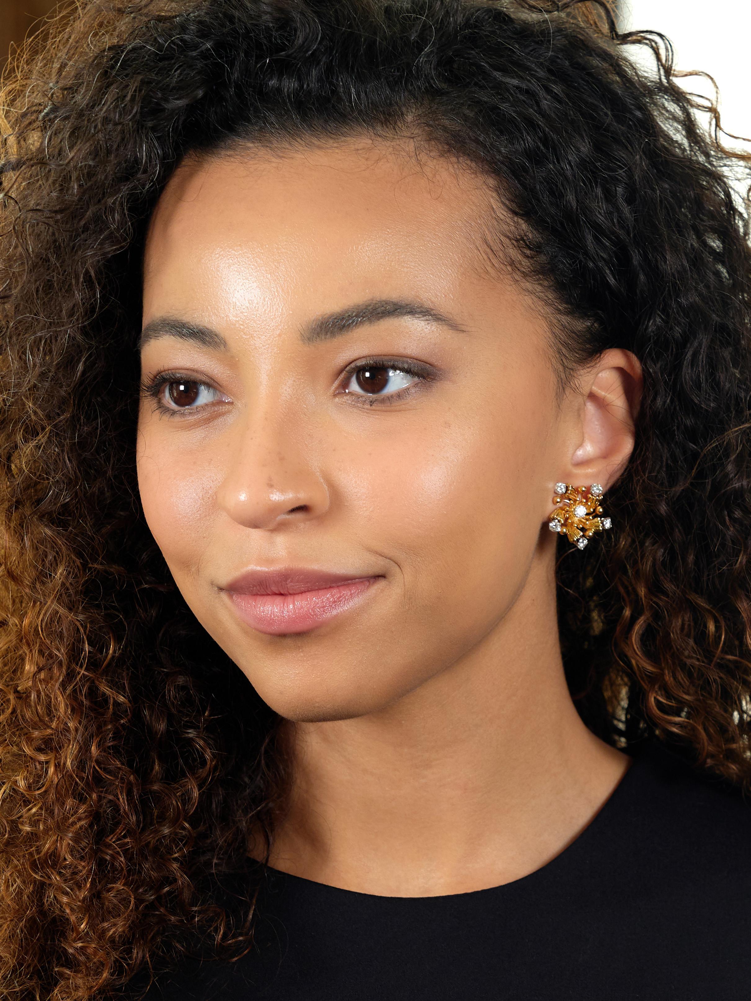 Stilisierte, wirbelnde Starburst-Motive aus Gelbgold
Akzentuiert durch geriffelte Details und radiale Granulationsausbrüche
Mit runden Diamanten im Brillantschliff in Platin gefasst
Mit einem Gesamtgewicht von etwa 2,20 Karat
Farbe G mit Klarheit