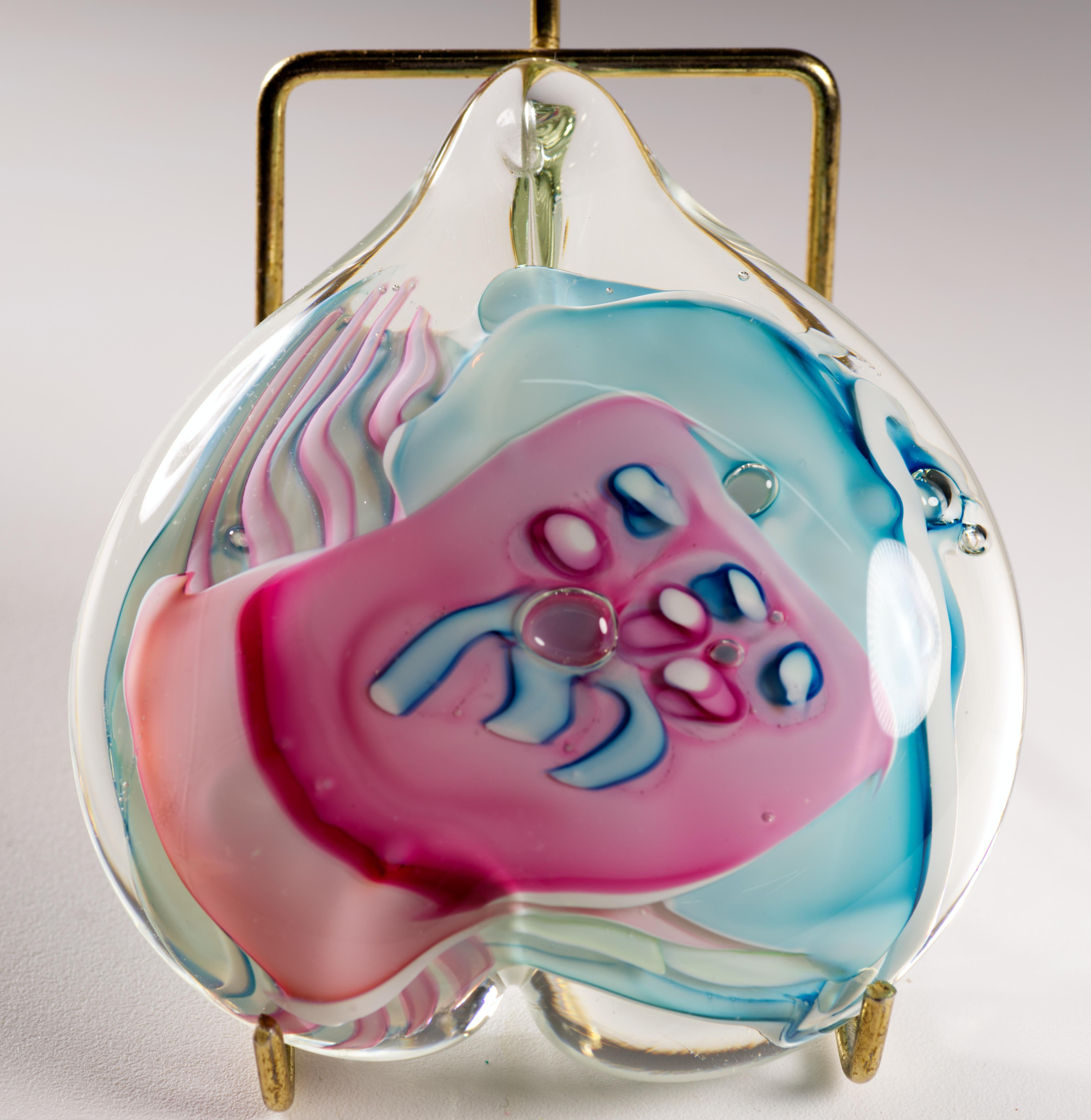  Ce presse-papier en verre d'art post-moderne coloré présente un motif abstrait complexe en verre fusionné, enfermé dans un verre transparent en forme de cœur, selon la technique sommerso. La palette bleue, rose et blanche est utilisée en