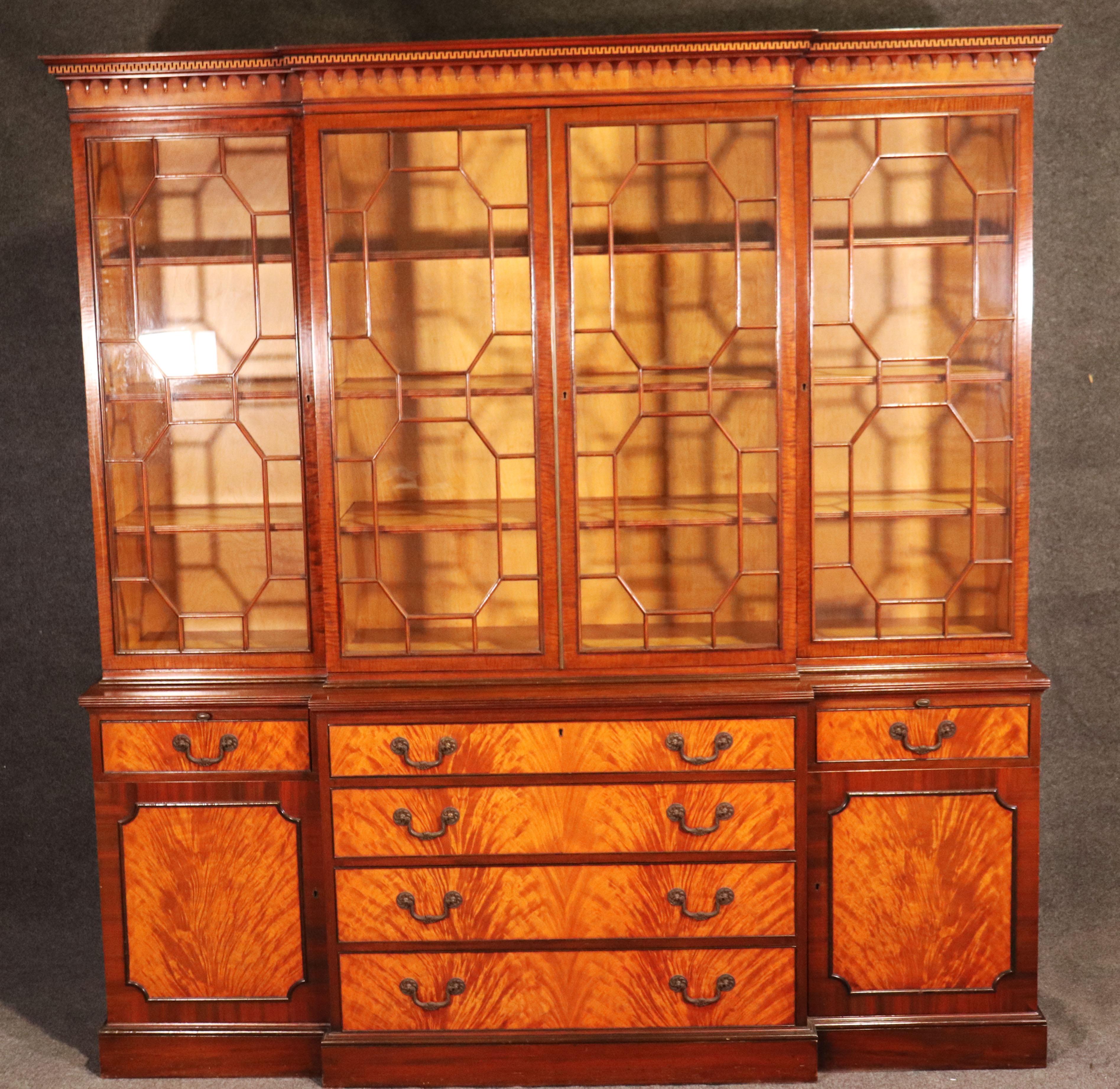This is a fine quality breakfront bookcase from one of America's finest manufacturers in our nation's history. This incredibly well made, crotch grain walnut and solid mahogany breakfront features individual glazed mullions on the doors and