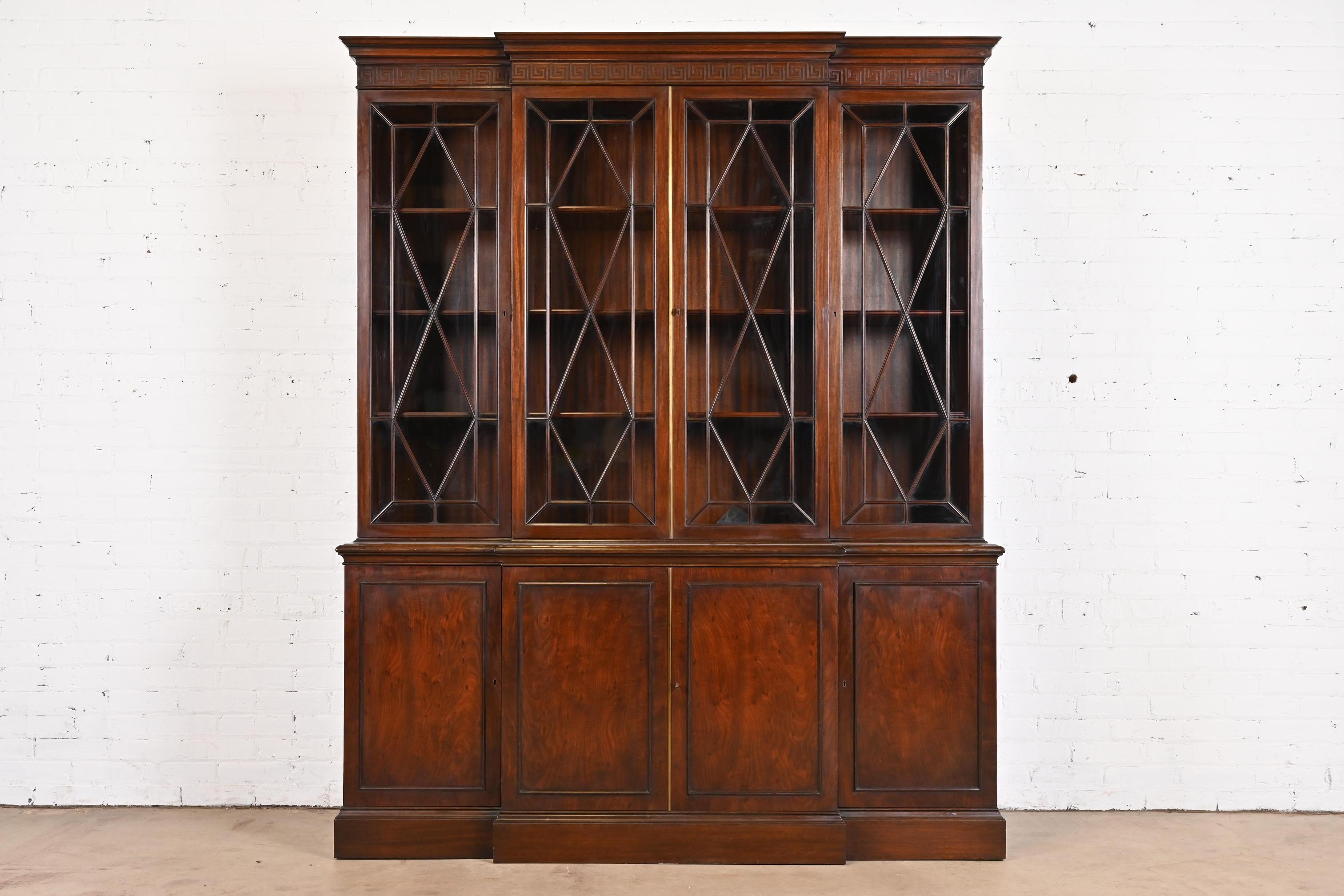 A gorgeous Georgian or Chippendale style breakfront bookcase or dining cabinet 

By Schmieg & Kotzian

USA, Circa 1940s

Mahogany, with carved Greek key design, mullioned glass front doors, and brass hardware. Cabinet locks, and key is