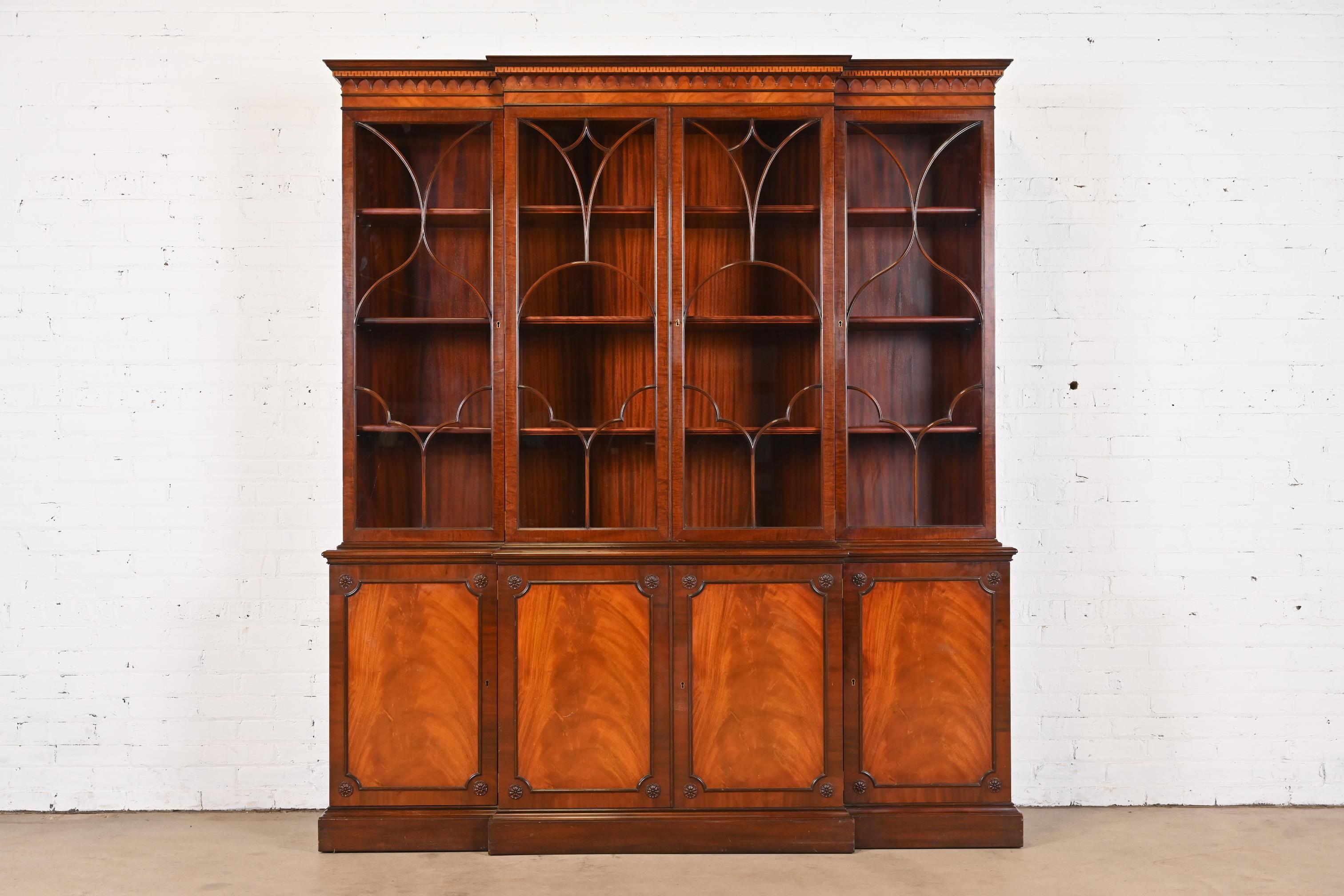 A gorgeous Georgian or Chippendale style breakfront bookcase or dining cabinet

By Schmieg & Kotzian

USA, Circa 1940s

Carved mahogany, with mullioned glass front doors, and brass hardware.

Measures: 72.75