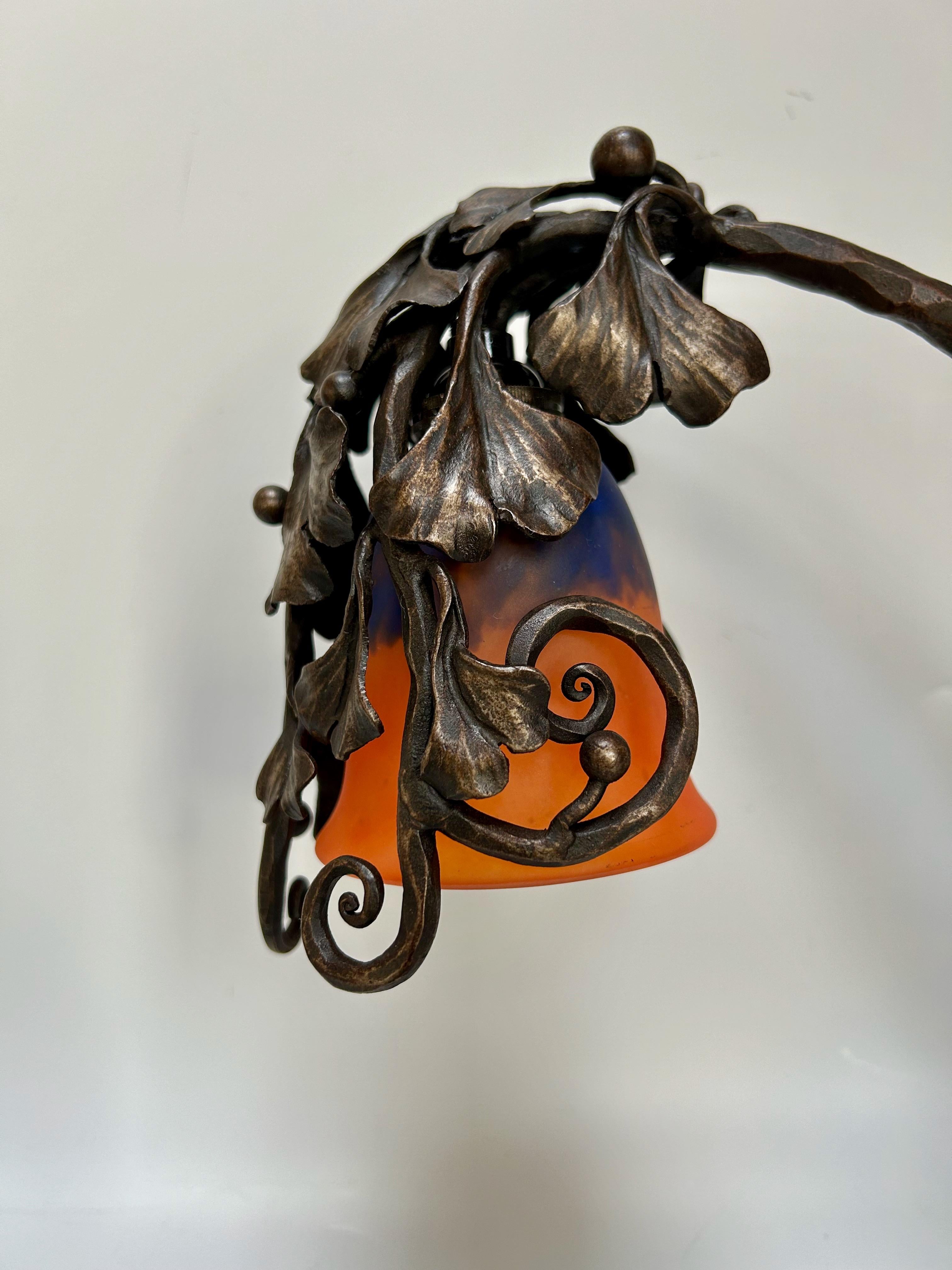 Lampe Art Déco circa 1925.
Base en fer forgé à décor de gingko biloba estampillée A. Moyens (ferronnier d'art de Marseille).
Tulipe en pâte de verre signée Schneider.
En parfait état et électrifié. Douille B22, ampoule à baïonnette.

Hauteur totale